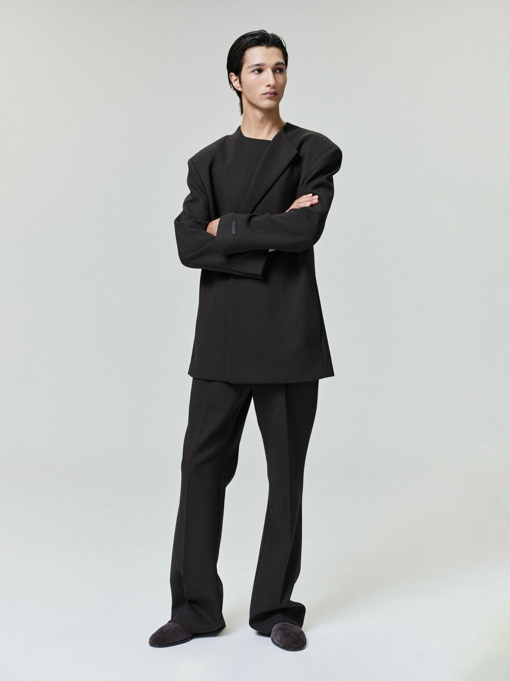 male model in black double-weave virgin wool tailored high-waisted flared pants with matching structured jacket