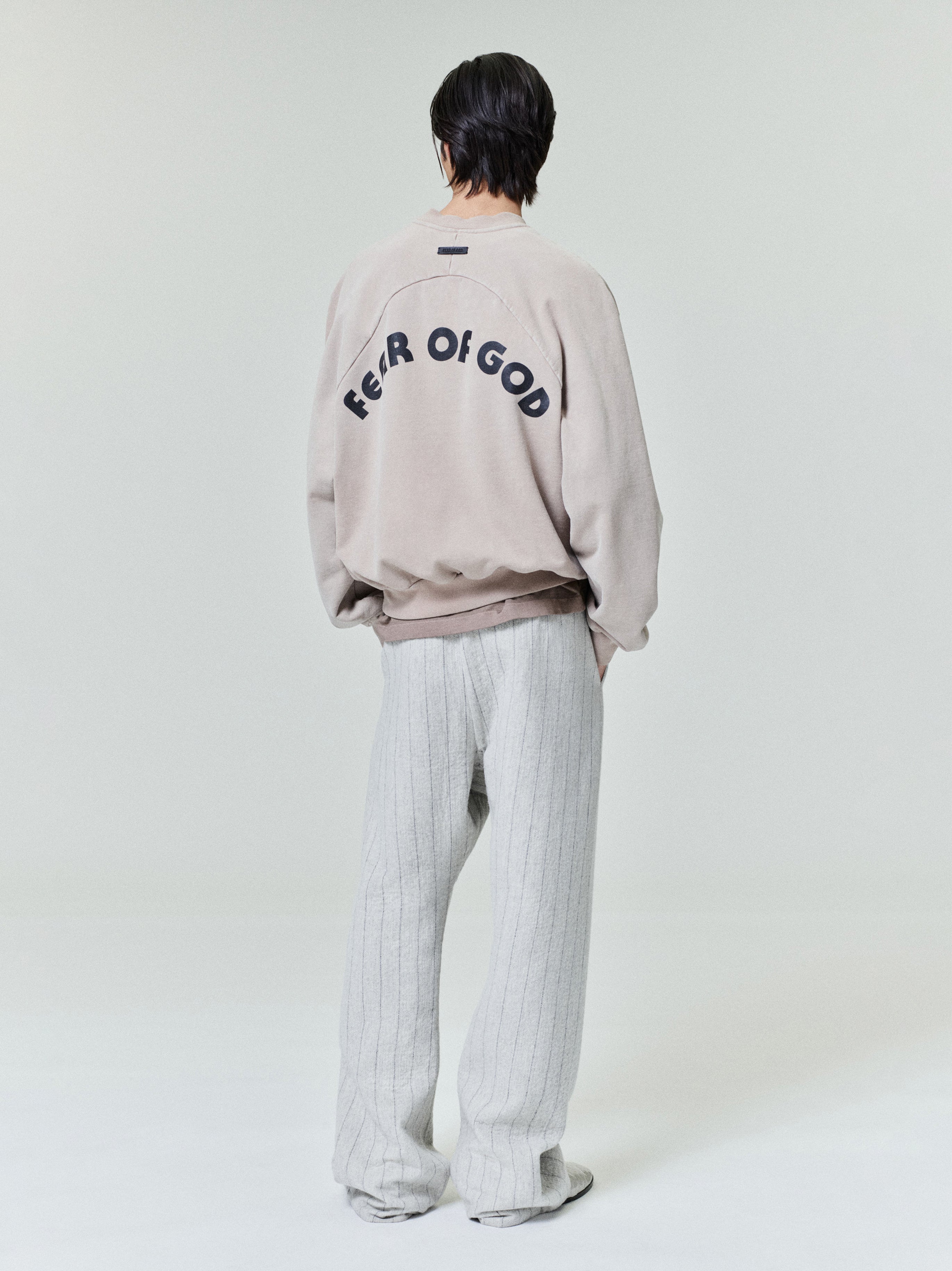male model wearing light grey pinstriped double face wool nylon baseball flared pants with elasticated back