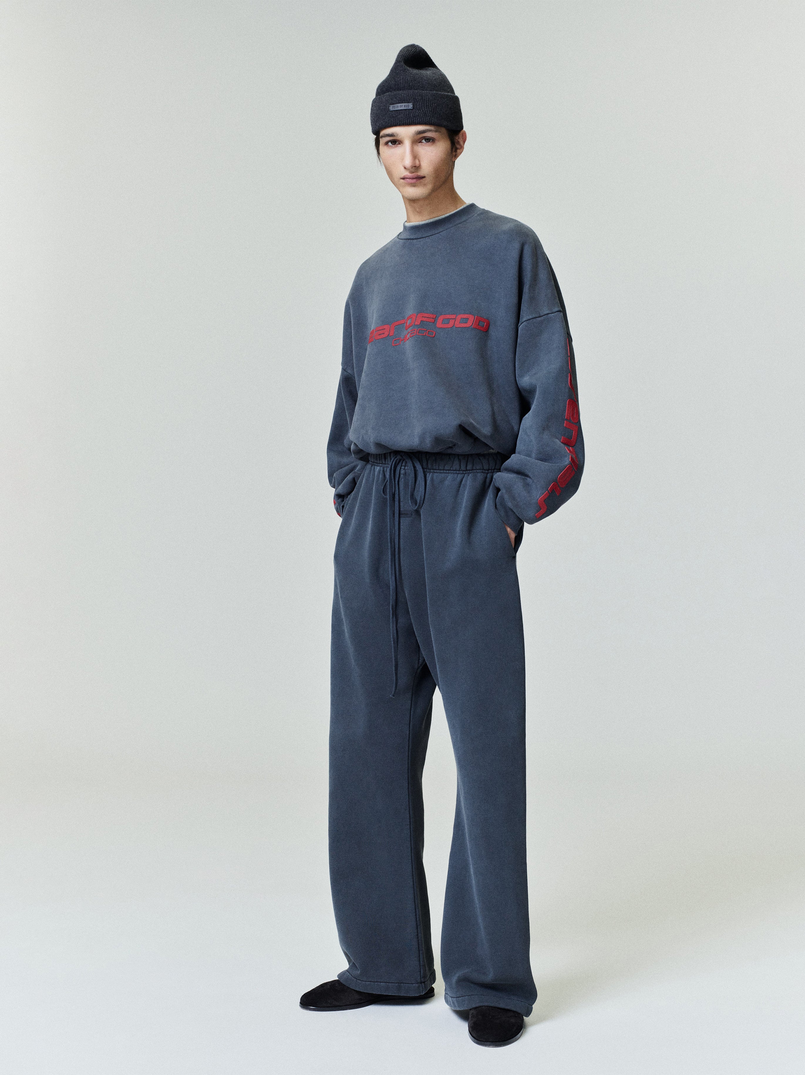Model wearing slate gray Heavy Fleece Flare Sweatpant with drawstring waistband, paired with matching graphic long sleeve and beanie, gallery 0