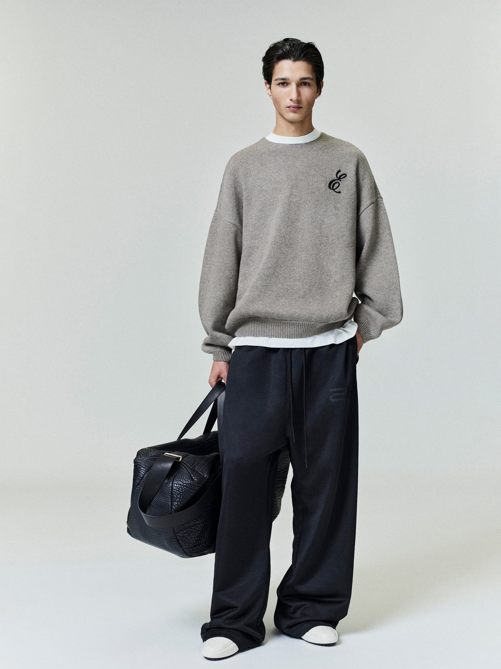 Model wearing black Satin Fleece Lounge Sweatpant with relaxed wide leg and subtle tonal logo detail, gallery position 0