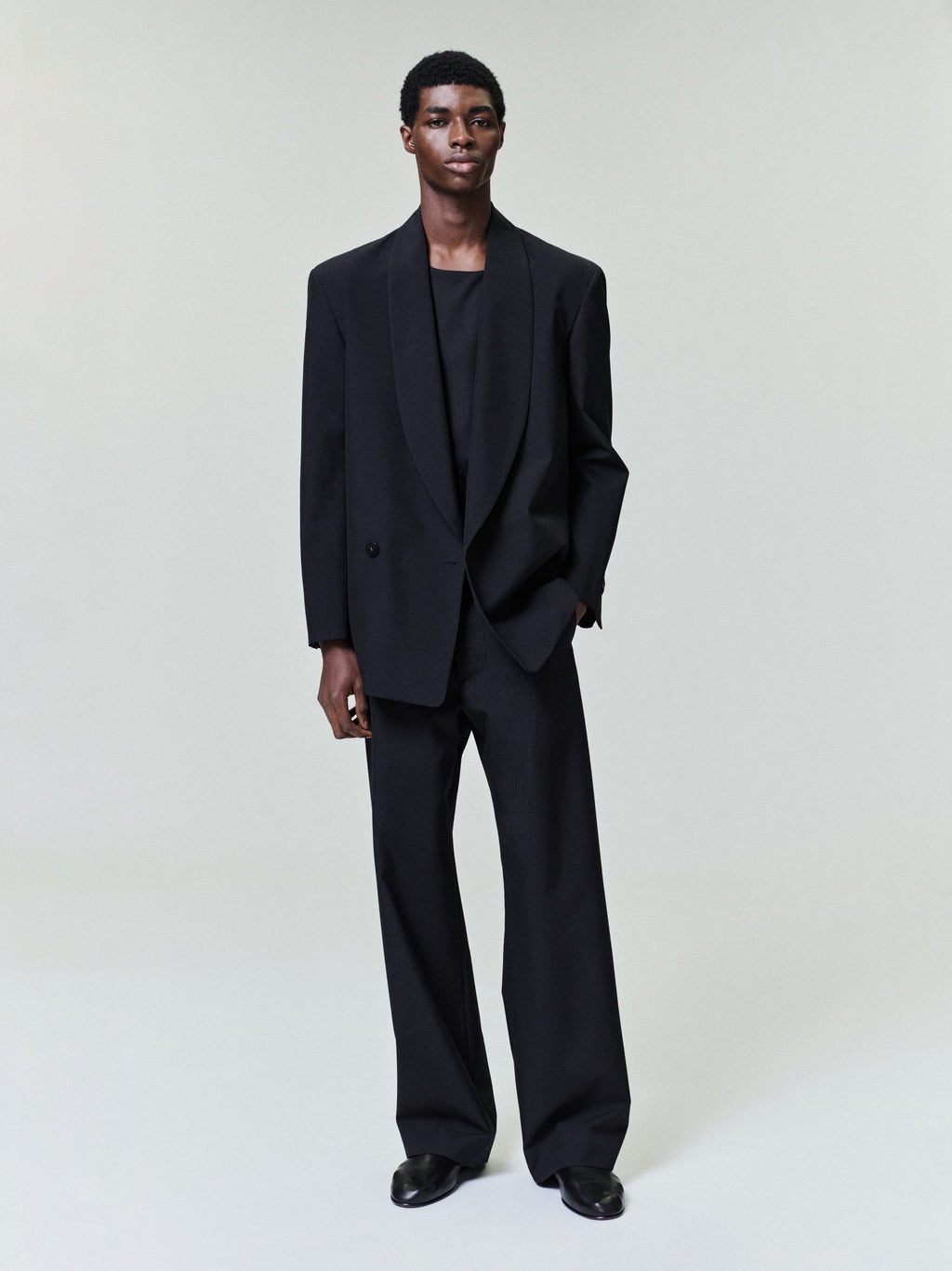 black wool poplin flat front casual pants with side seam pockets and relaxed straight leg fit on male model
