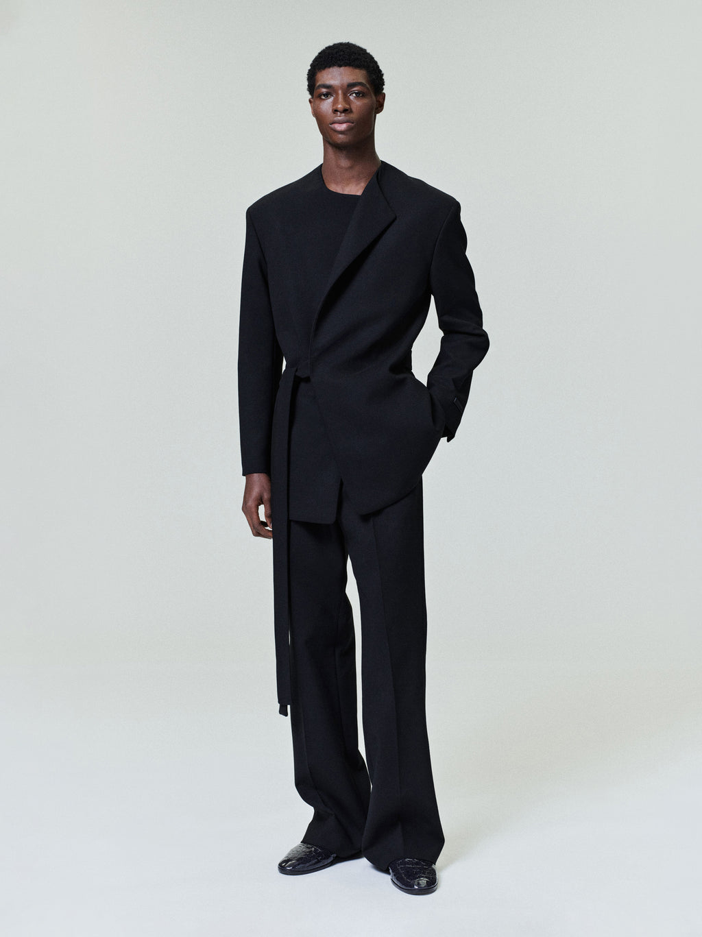 model wearing relaxed tailored double weave virgin wool crewneck jacket with side belt and matching pants