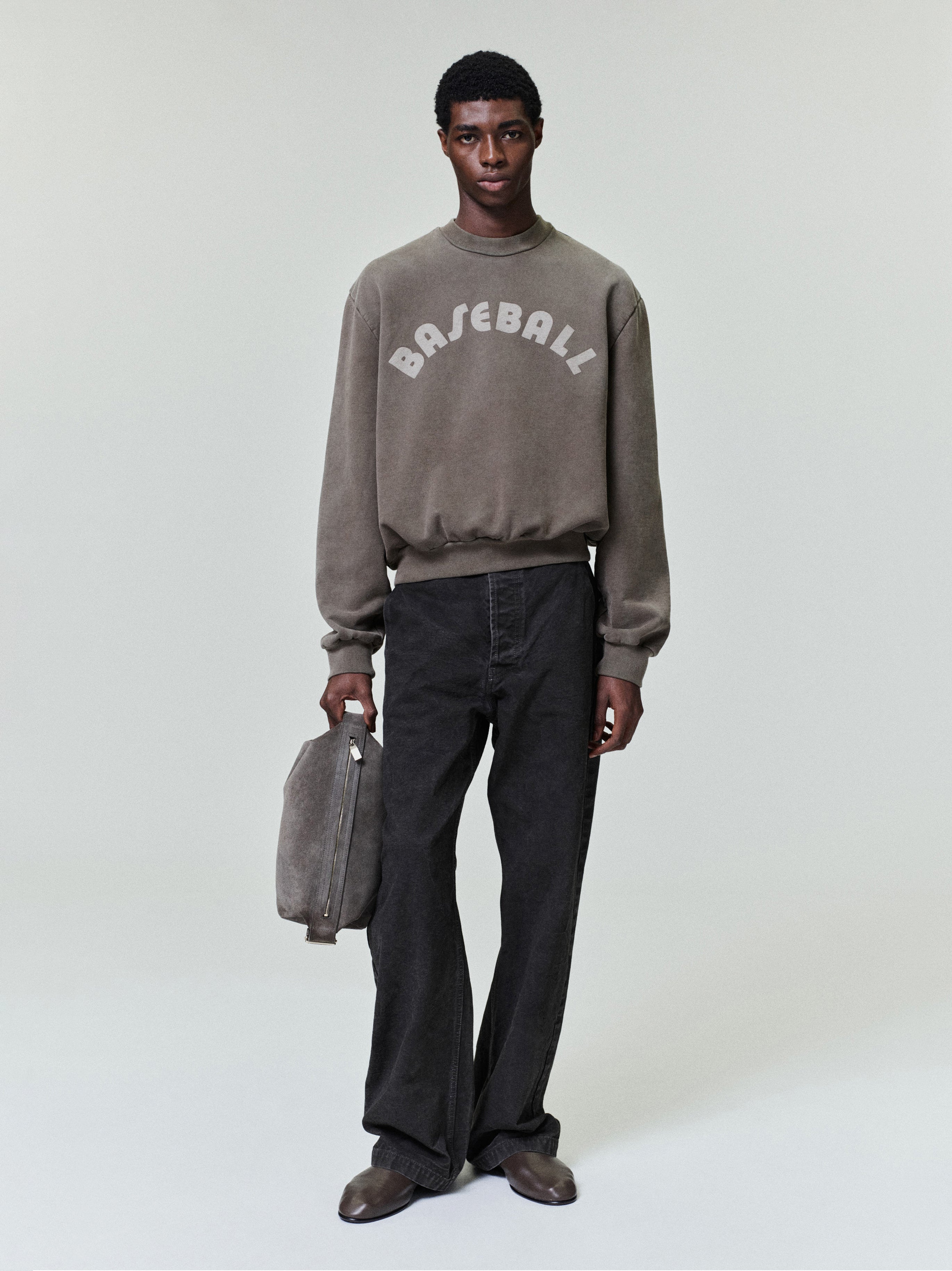 front view of relaxed fit washed canvas utility pants paired with matching gray sweatshirt and suede shoes