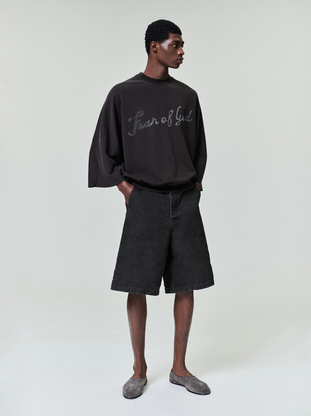 model wearing relaxed fit black washed canvas utility shorts with side seam and back waistband pockets