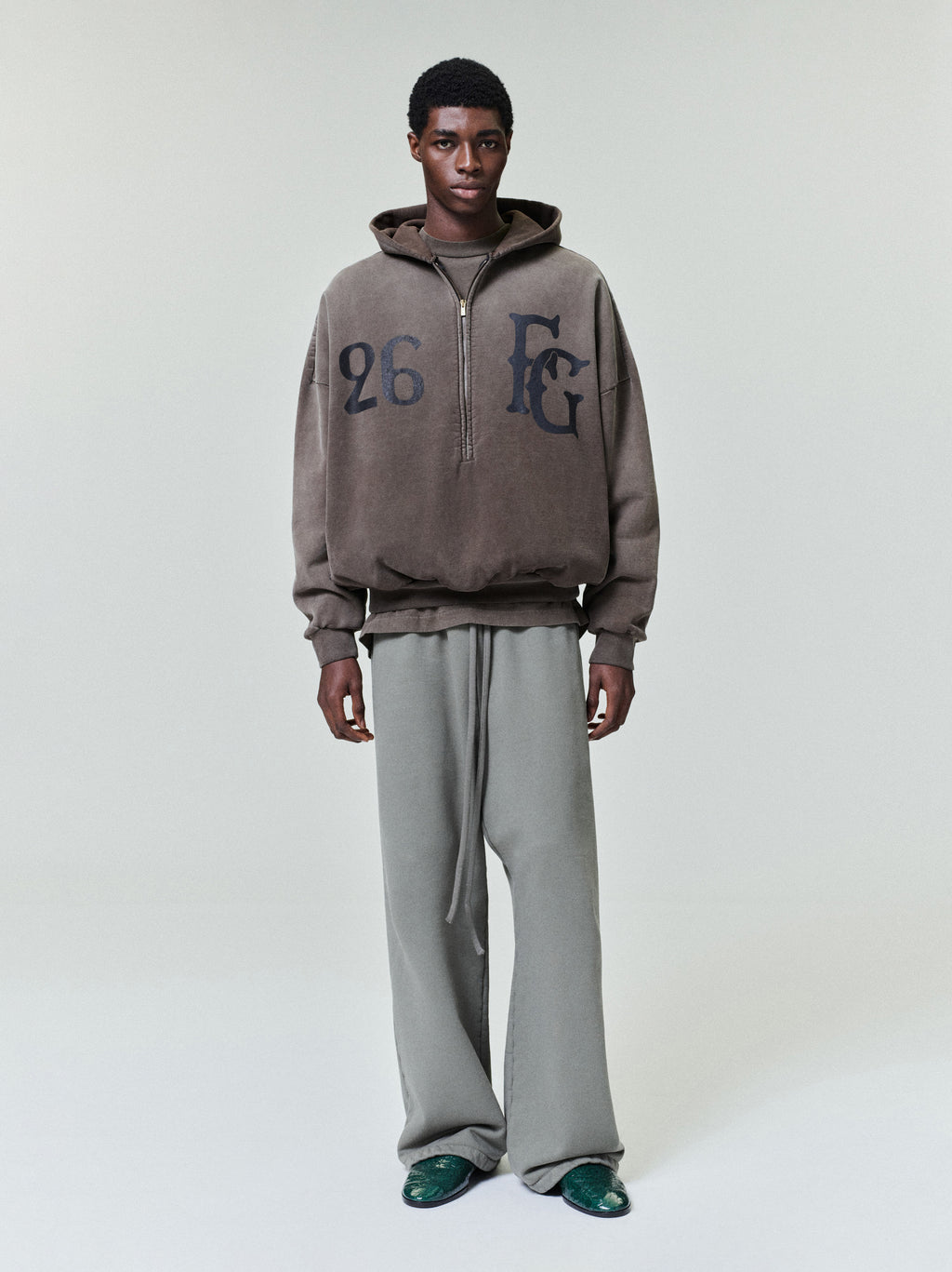 male model wearing loose fit wide leg sweatpants with elastic waistband and long drawstring front view
