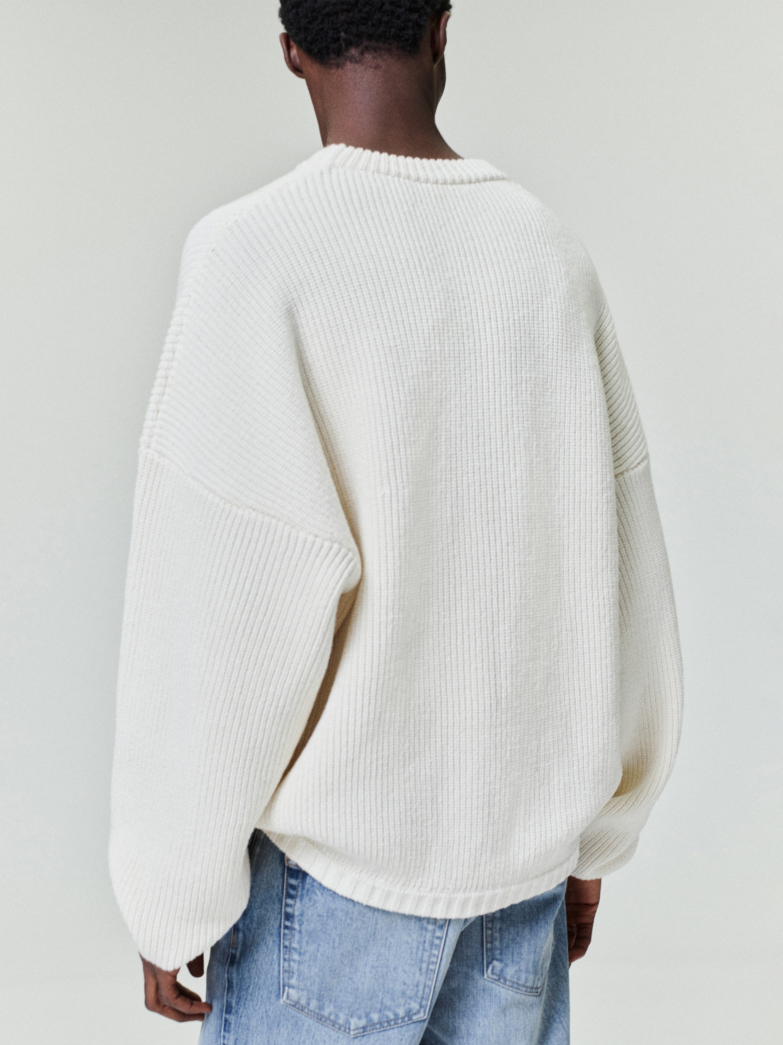 back view of men's off-white double knit linen wool cotton crewneck sweater with relaxed fit and ribbed detailing