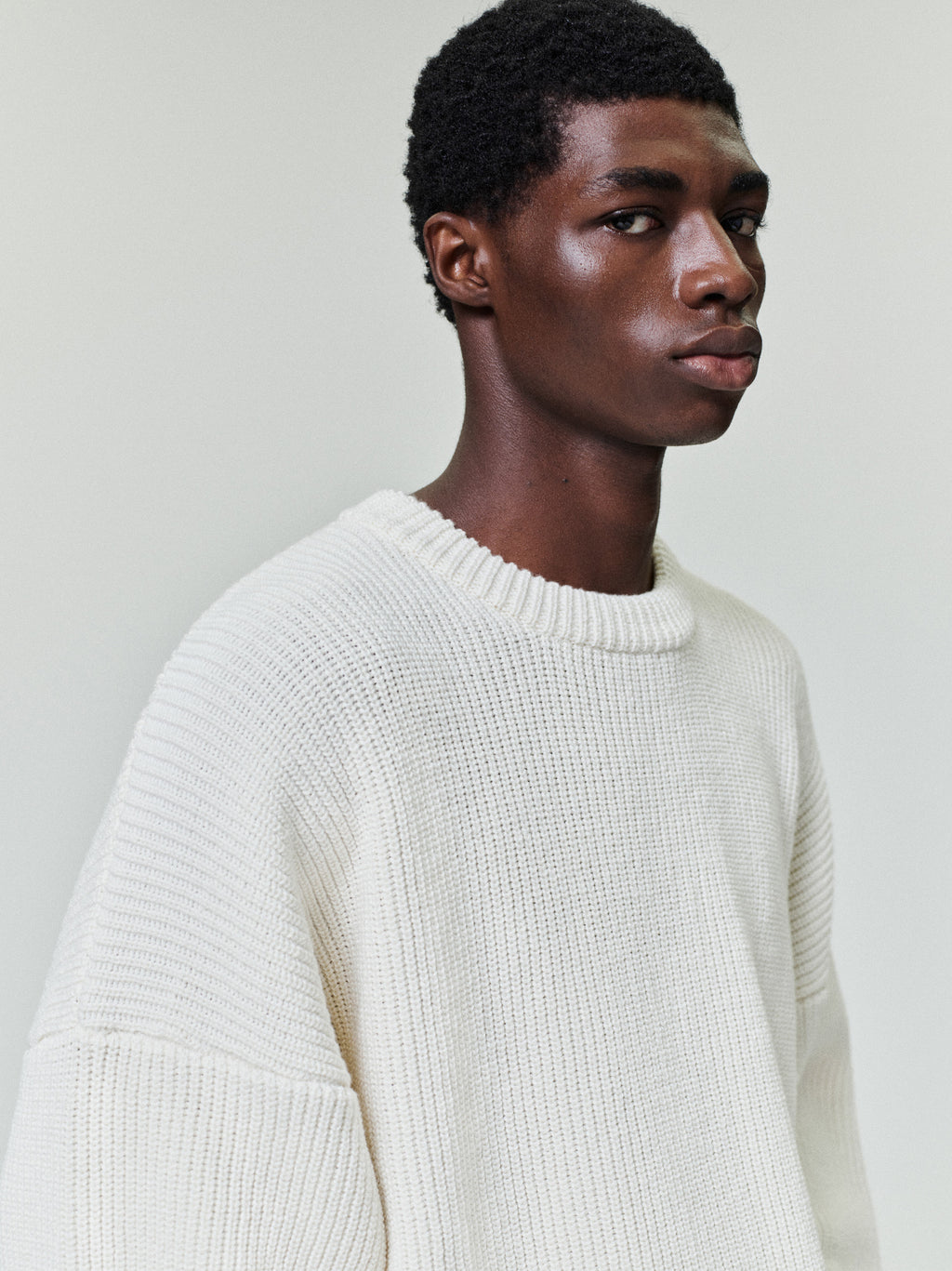 side profile of men's off-white double knit linen wool cotton crewneck sweater with relaxed fit and ribbed collar