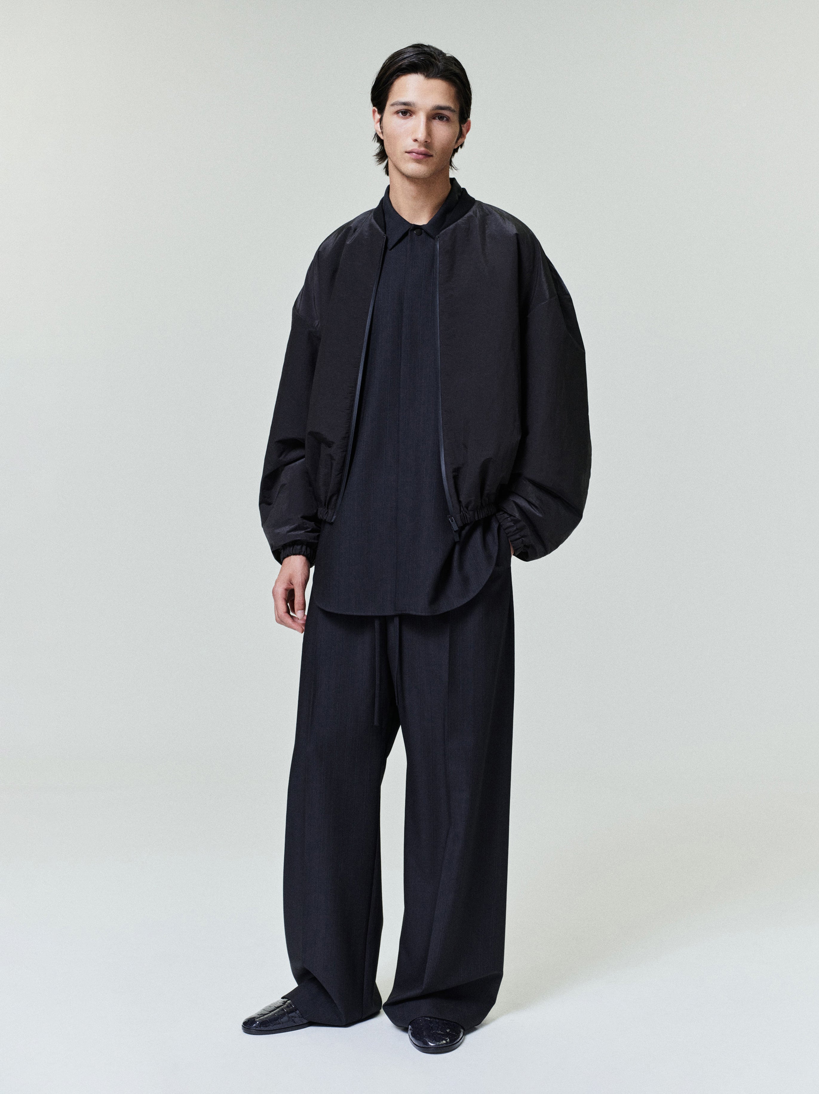 model wearing black lightweight nylon taffeta padded bomber jacket with elastic cuffs and knit collar