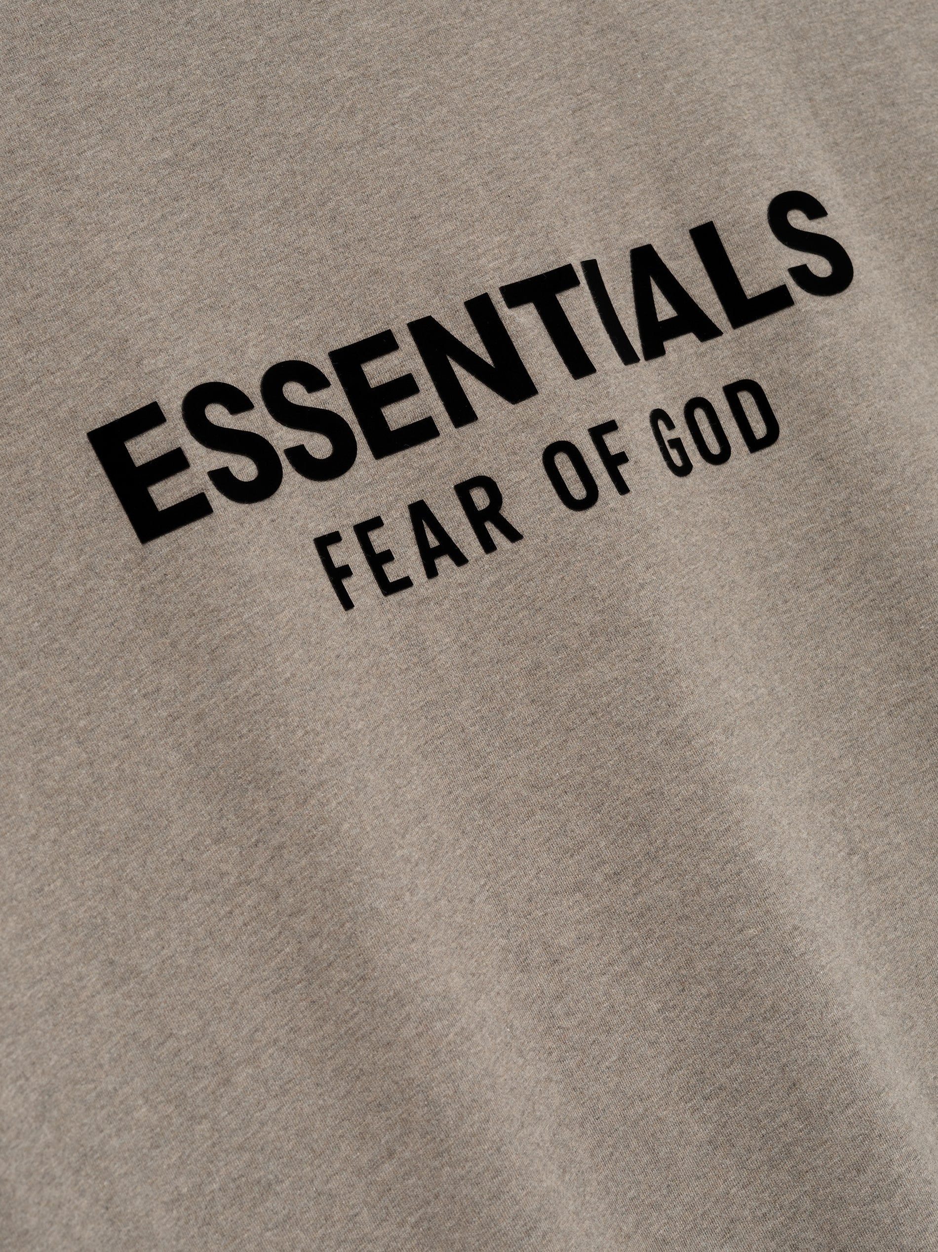 Close-up of Homestead Heather Classic Short Sleeve Tee showing black ESSENTIALS Fear of God logo on chest, gallery image 0