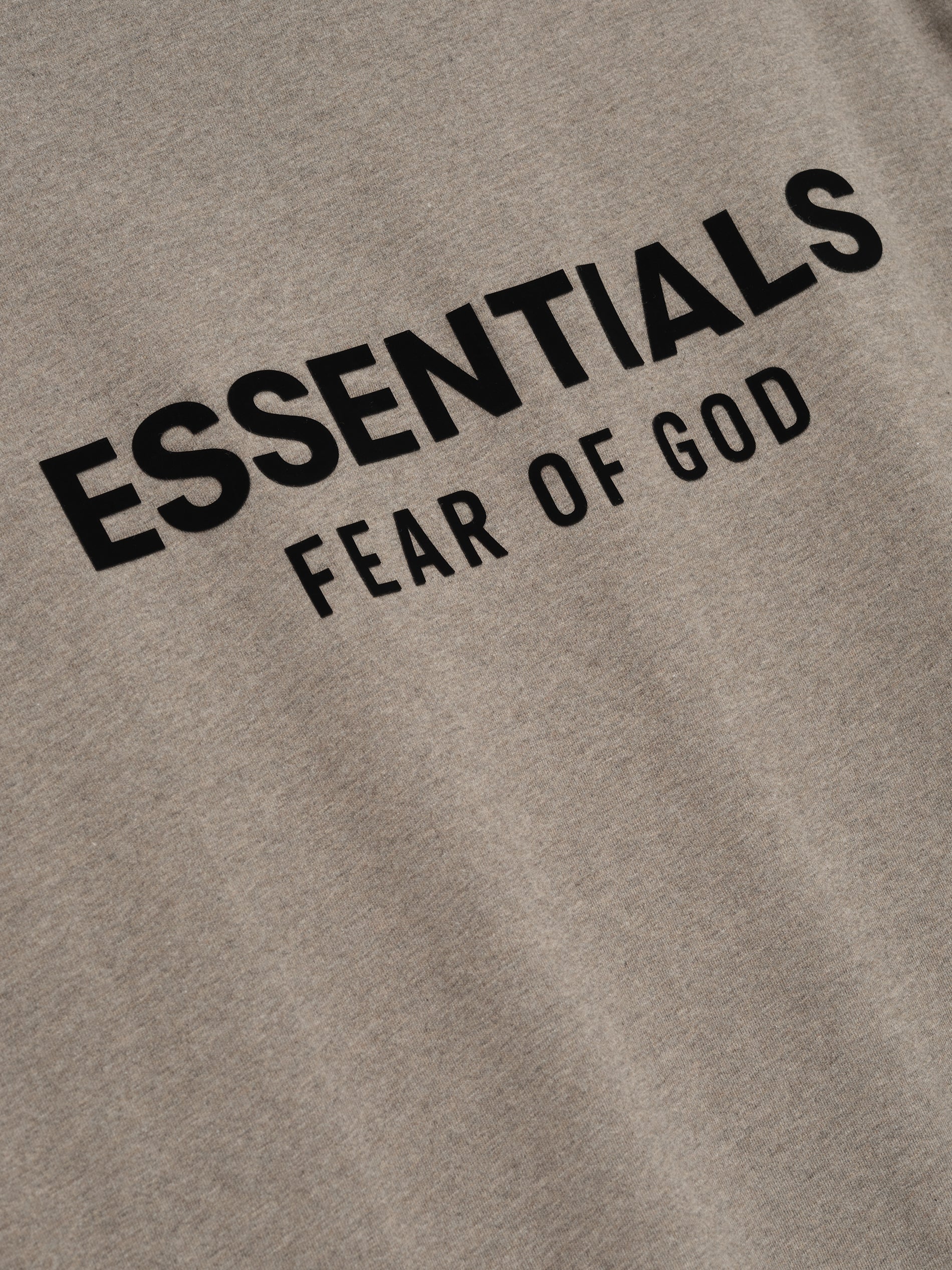 Taupe classic long sleeve tee with bold black ESSENTIALS Fear of God logo printed on chest area in clean font