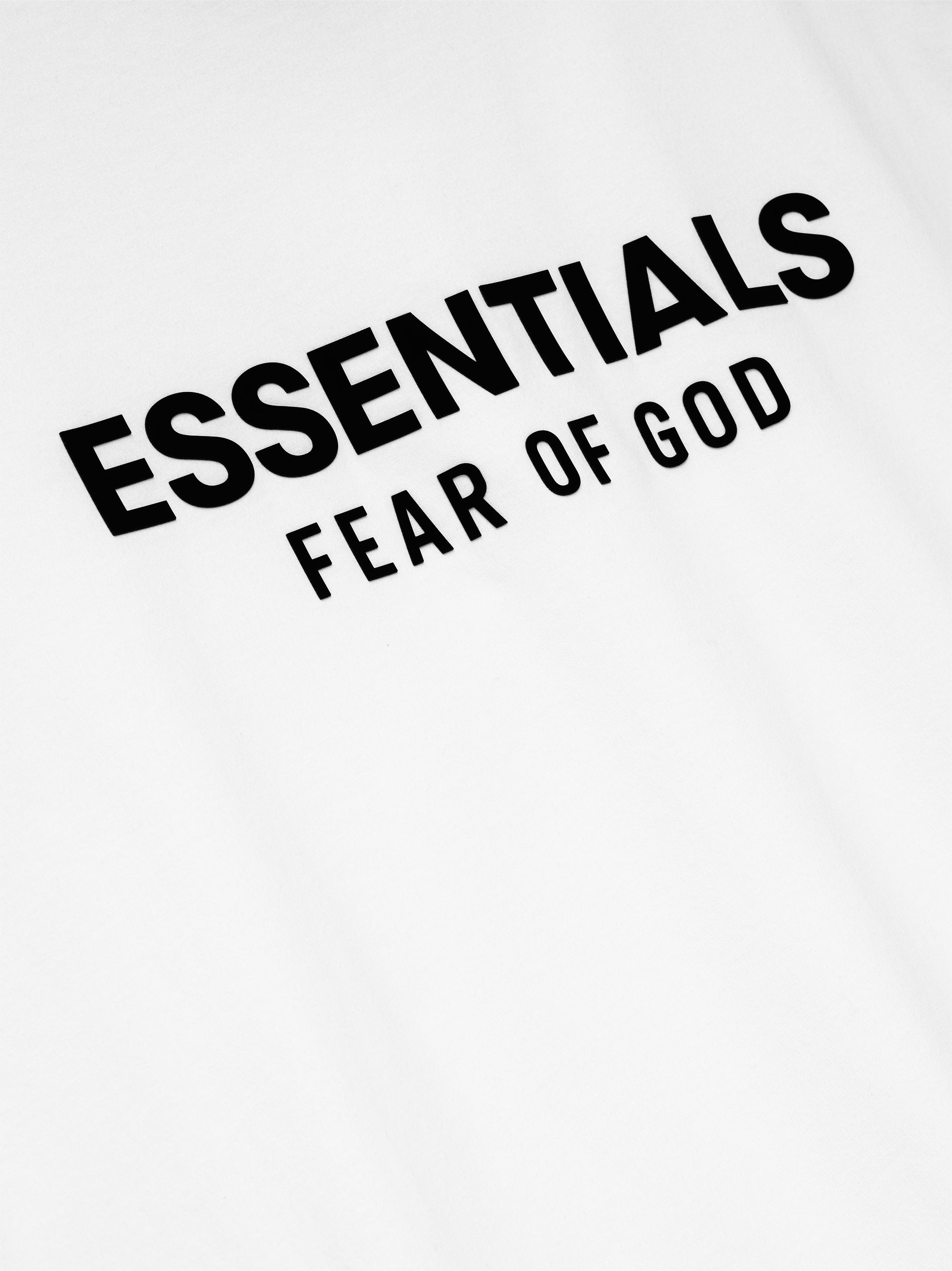 Close-up of bright white Classic Long Sleeve Tee showing bold black ESSENTIALS Fear of God logo, image 125AS254202F gallery 0