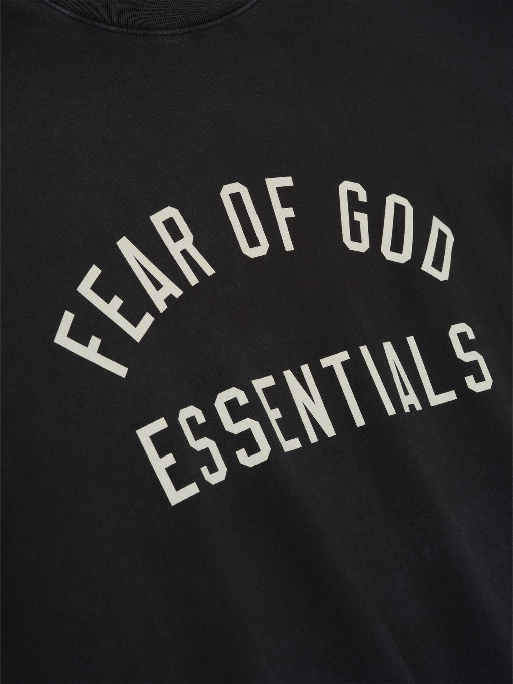 Close-up of vintage black 90s Short Sleeve Tee featuring curved Fear of God ESSENTIALS print on chest