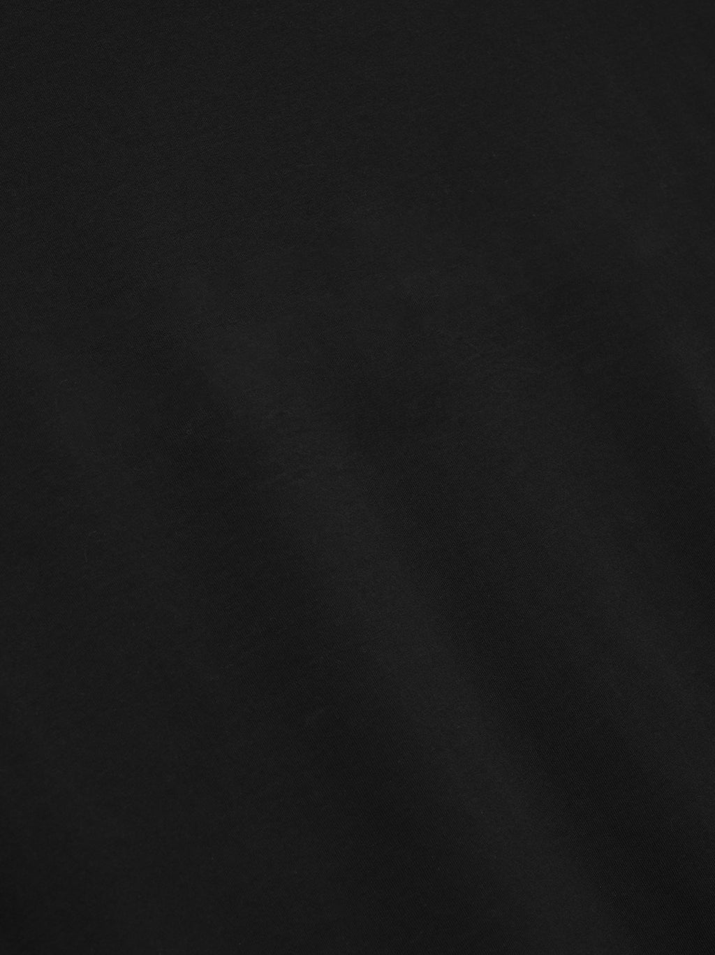 close-up of black medium-weight cotton jersey fabric with smooth texture and subtle drape