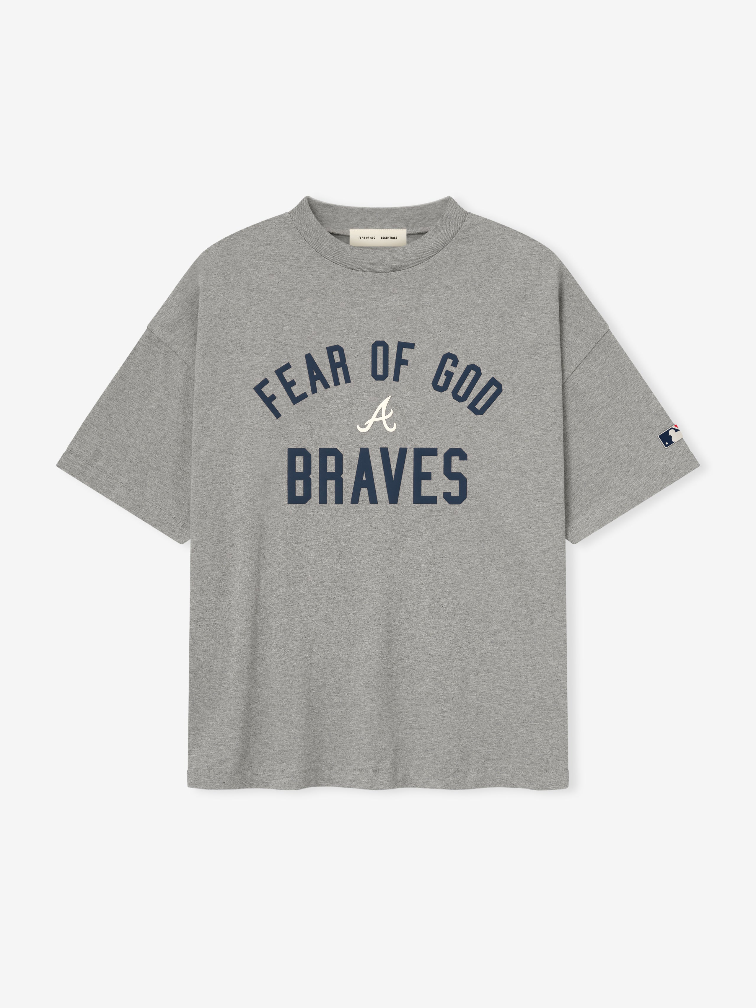 Light grey t-shirt with navy "FEAR OF GOD" arching above cursive white "A" and bold navy "BRAVES" on front center