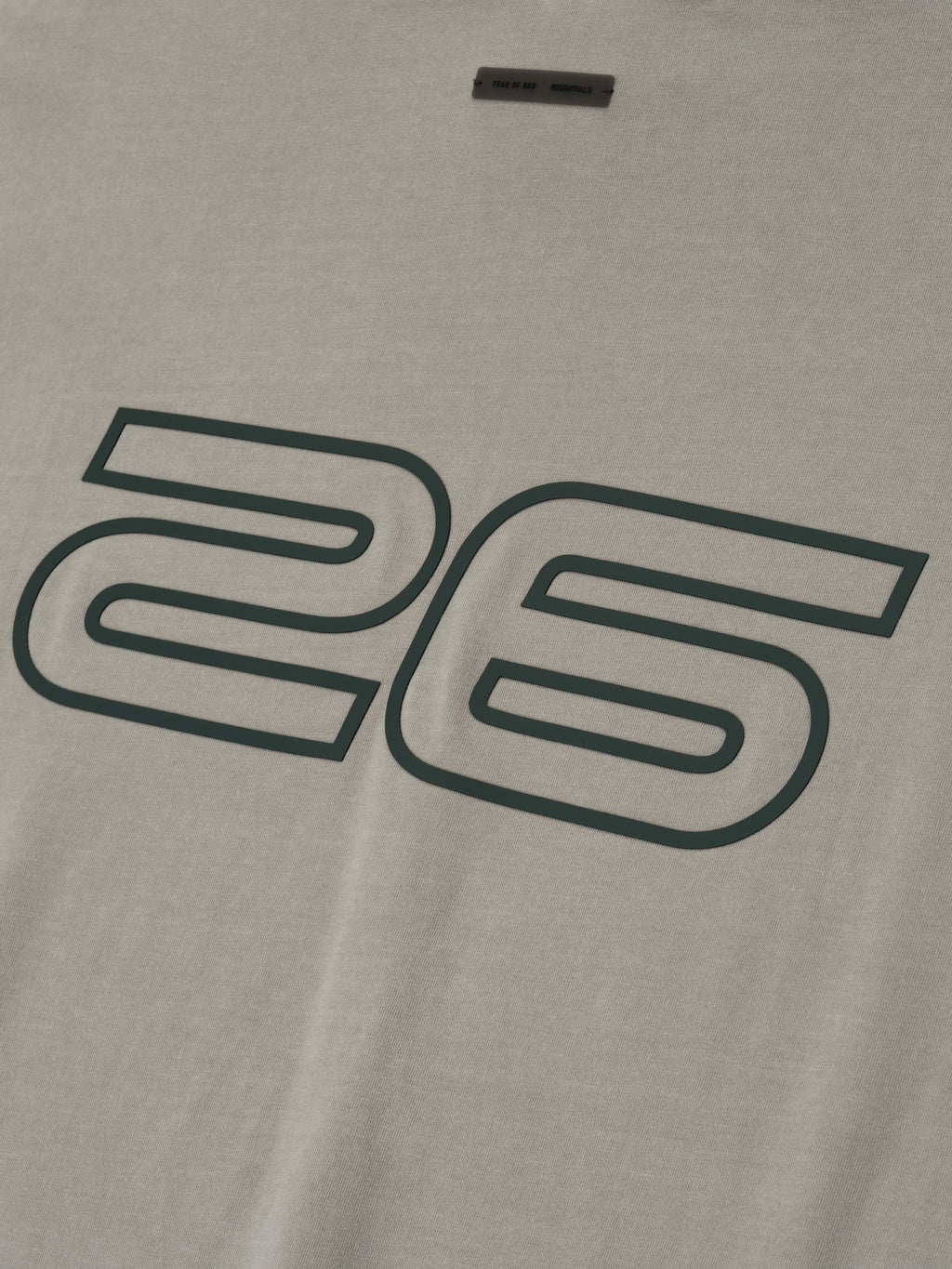Close-up of smoke grey Fear of God Essentials 90s Tee showing large outlined 26 print on soft cotton fabric