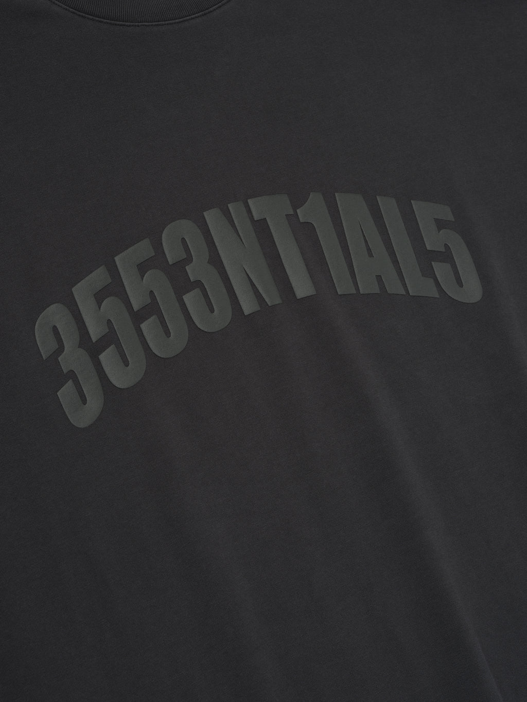 Close-up of vintage black Los Angeles 90s Tee with arched embossed alphanumeric print on soft fabric surface