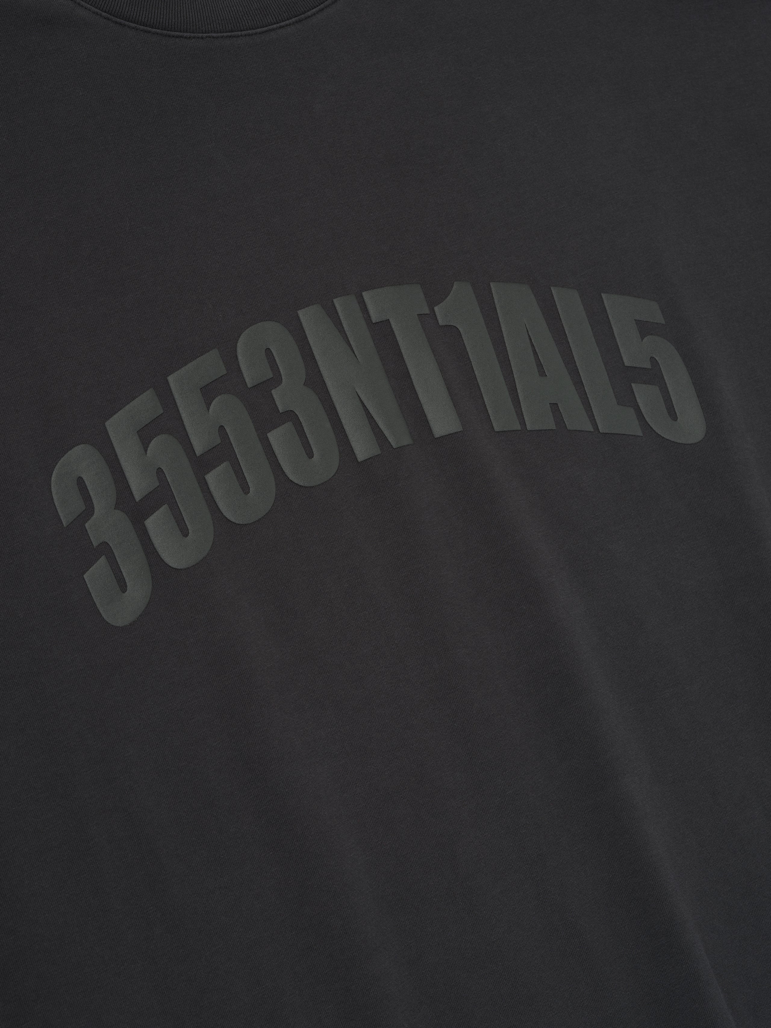 Close-up of vintage black Los Angeles 90s Tee with arched embossed alphanumeric print on soft fabric surface