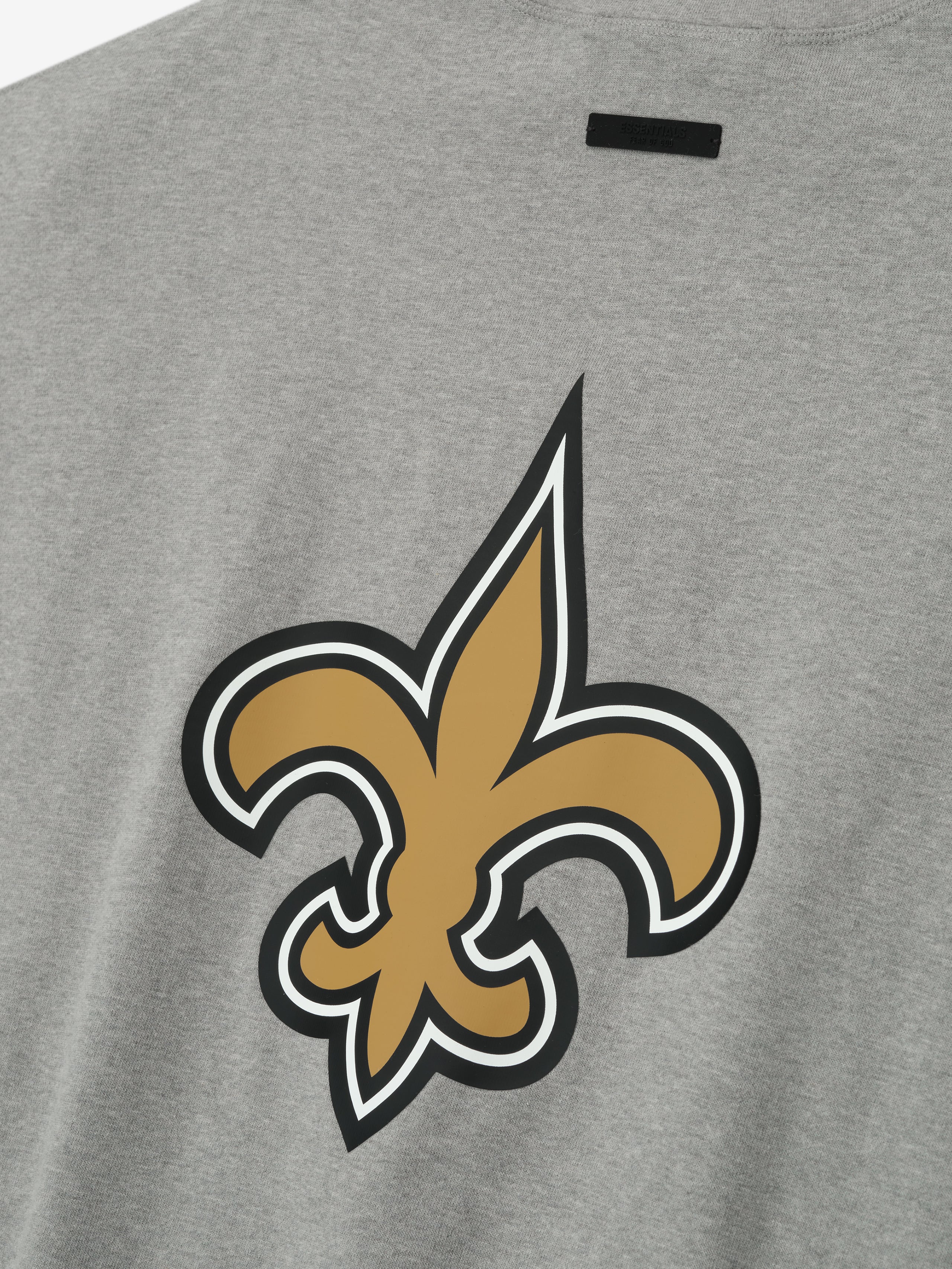 Close-up of concrete heather Saints 90s 3/4 Sleeve Football Tee showing large gold fleur-de-lis logo on back center