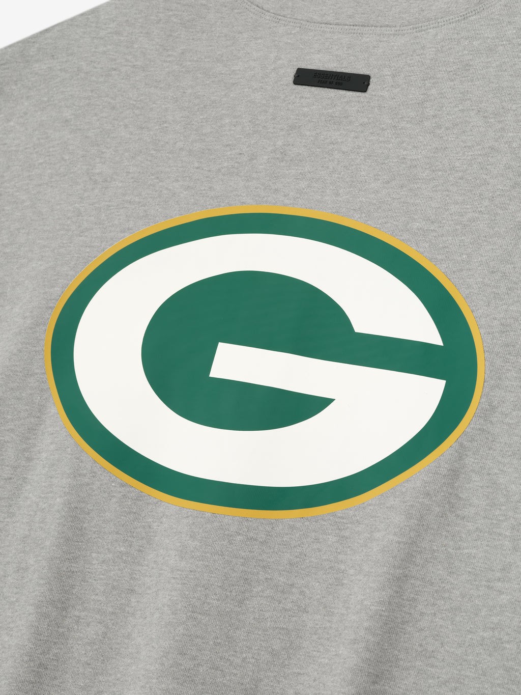 Close-up of concrete heather Packers 90s 3/4 Sleeve Football Tee showing large green and white G logo with gold outline centered