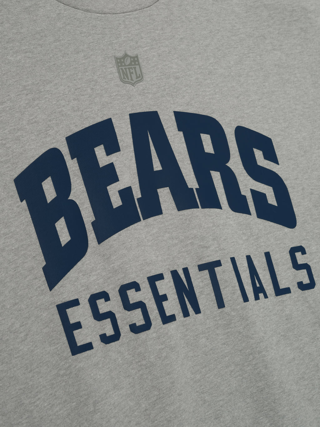 Close-up of concrete heather Bears 90s 3/4 Sleeve Football Tee showing navy Bears Essentials text on chest and NFL logo above