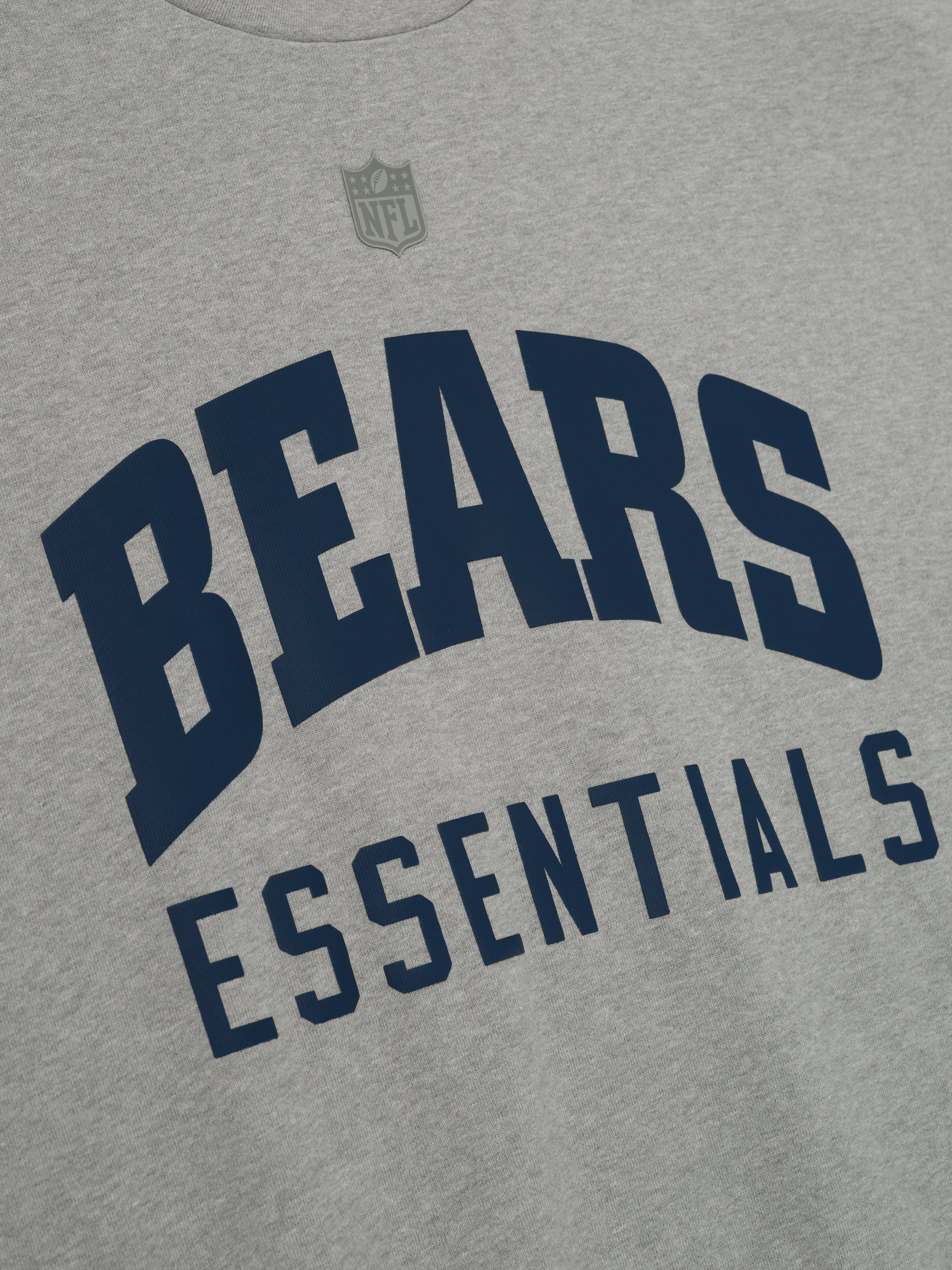 Close-up of concrete heather Bears 90s 3/4 Sleeve Football Tee showing navy Bears Essentials text on chest and NFL logo above