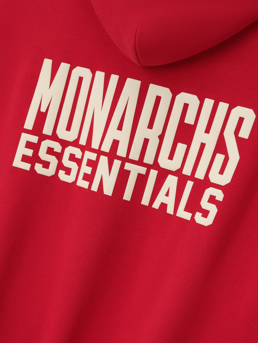 red hoodie back with bold cream "MONARCHS ESSENTIALS" text printed on smooth fleece fabric