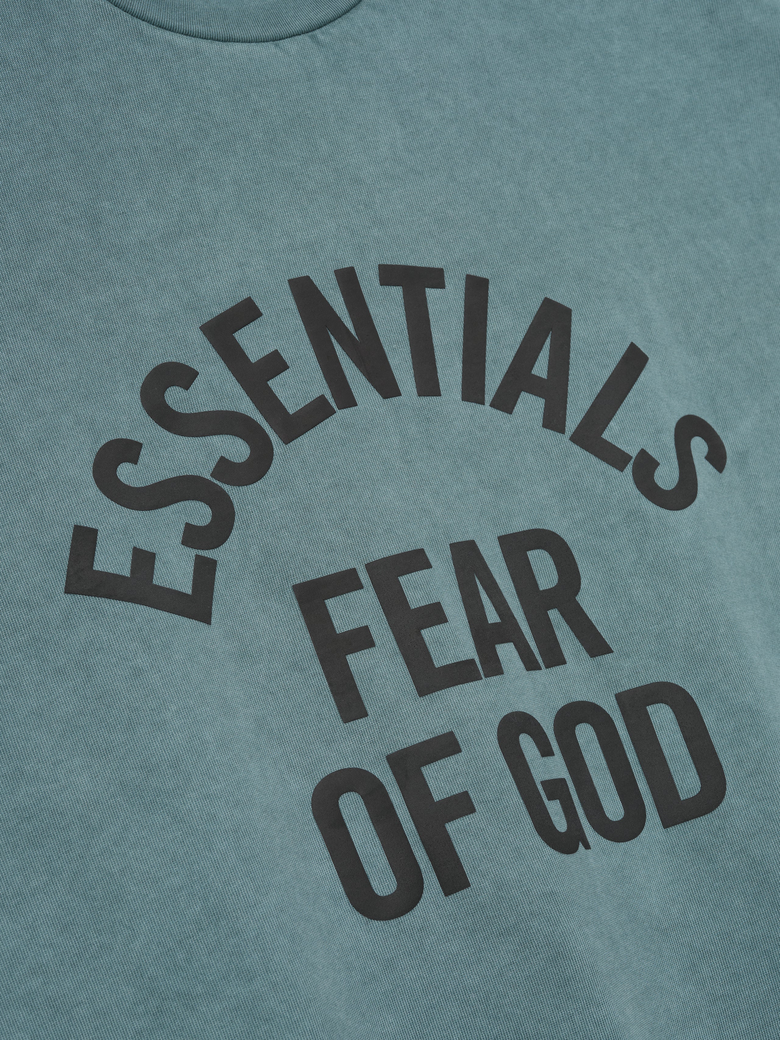 vintage pigment-dyed heavyweight cotton tee with arched ESSENTIALS FEAR OF GOD text in dark print on washed teal fabric