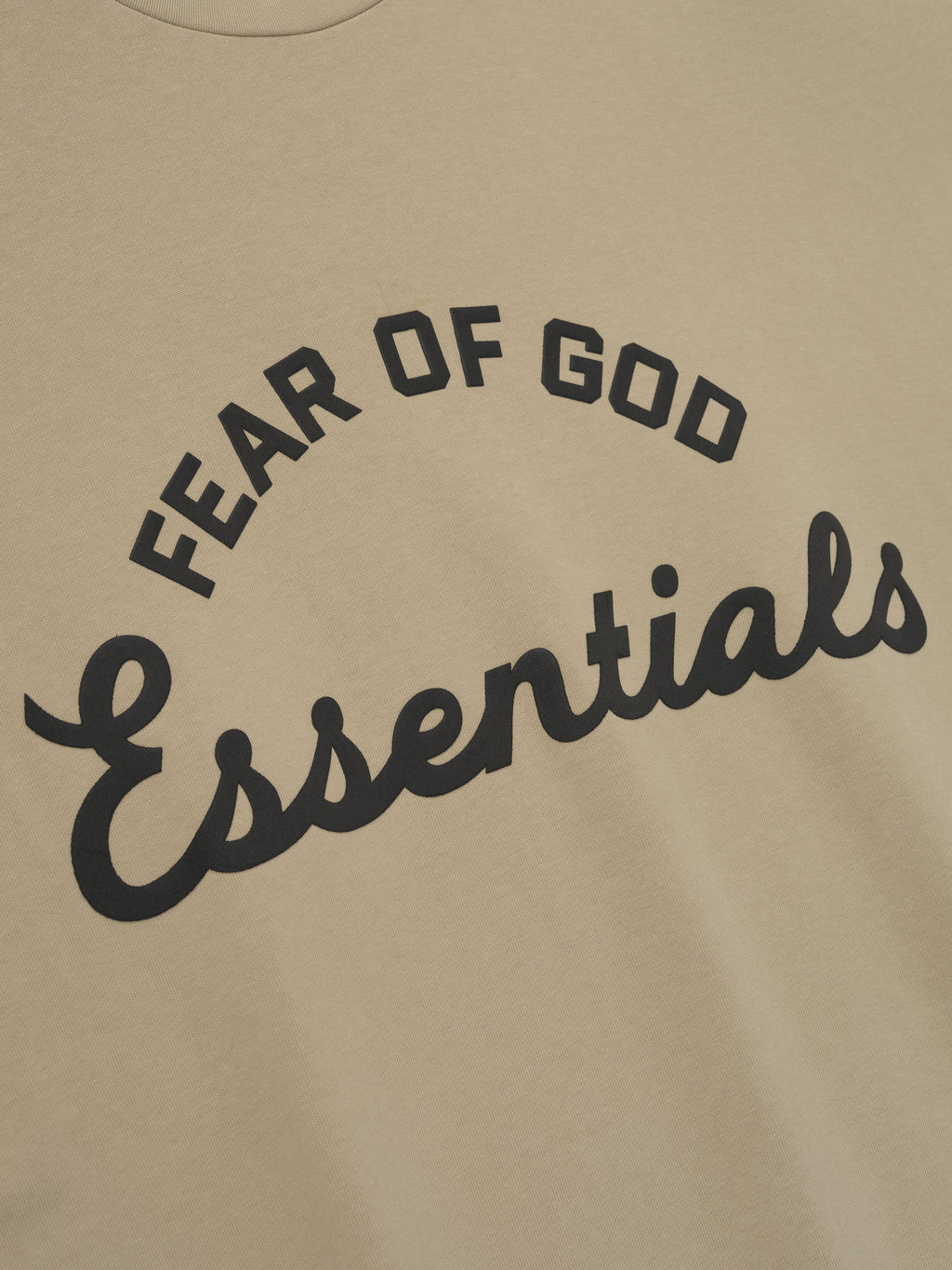 close-up of beige heavyweight cotton tee with arched Fear of God Essentials logo in black print front view