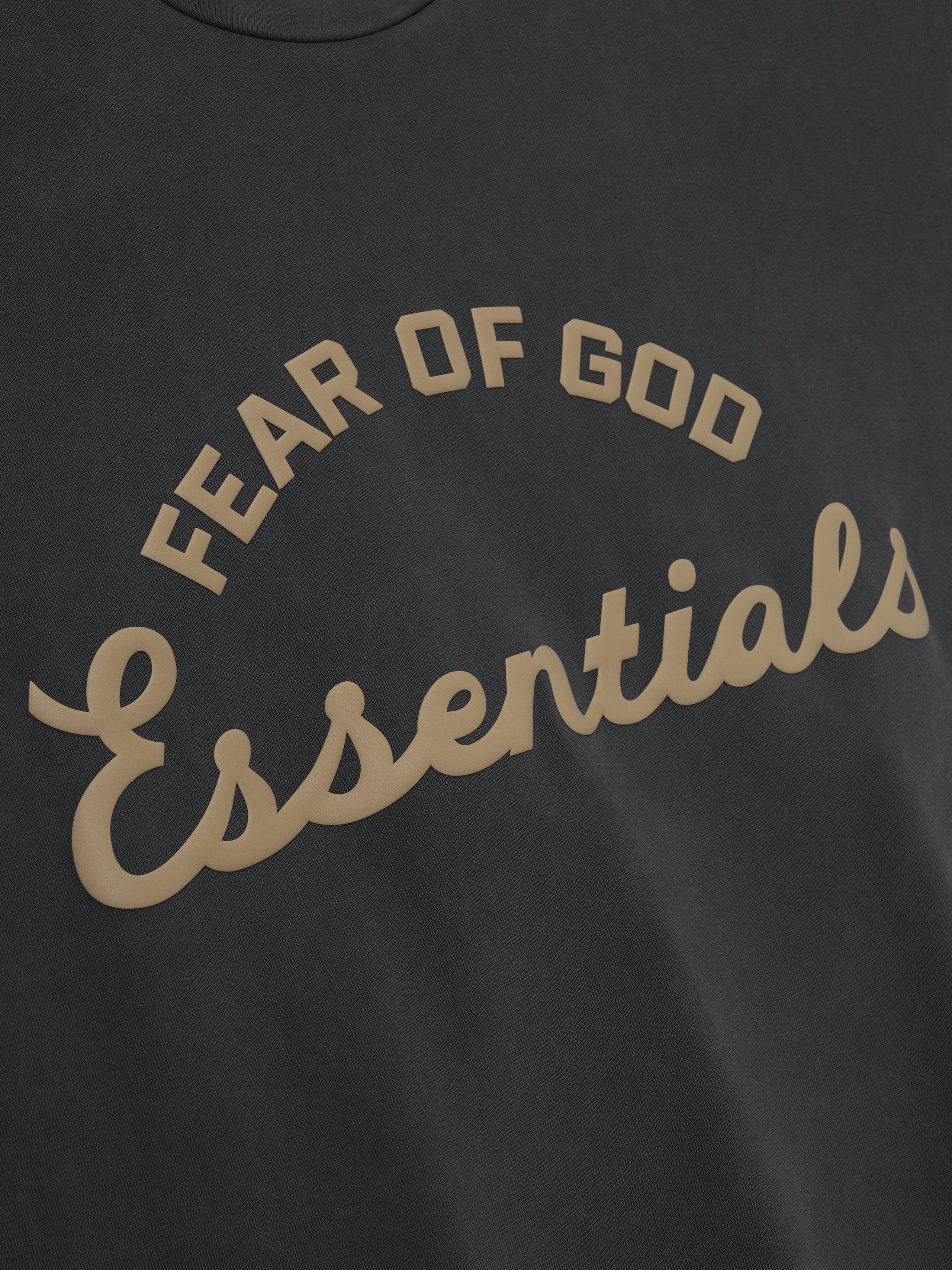 close-up of vintage black pigment-dyed 90s fit tee with Fear of God Essentials arched logo print in tan