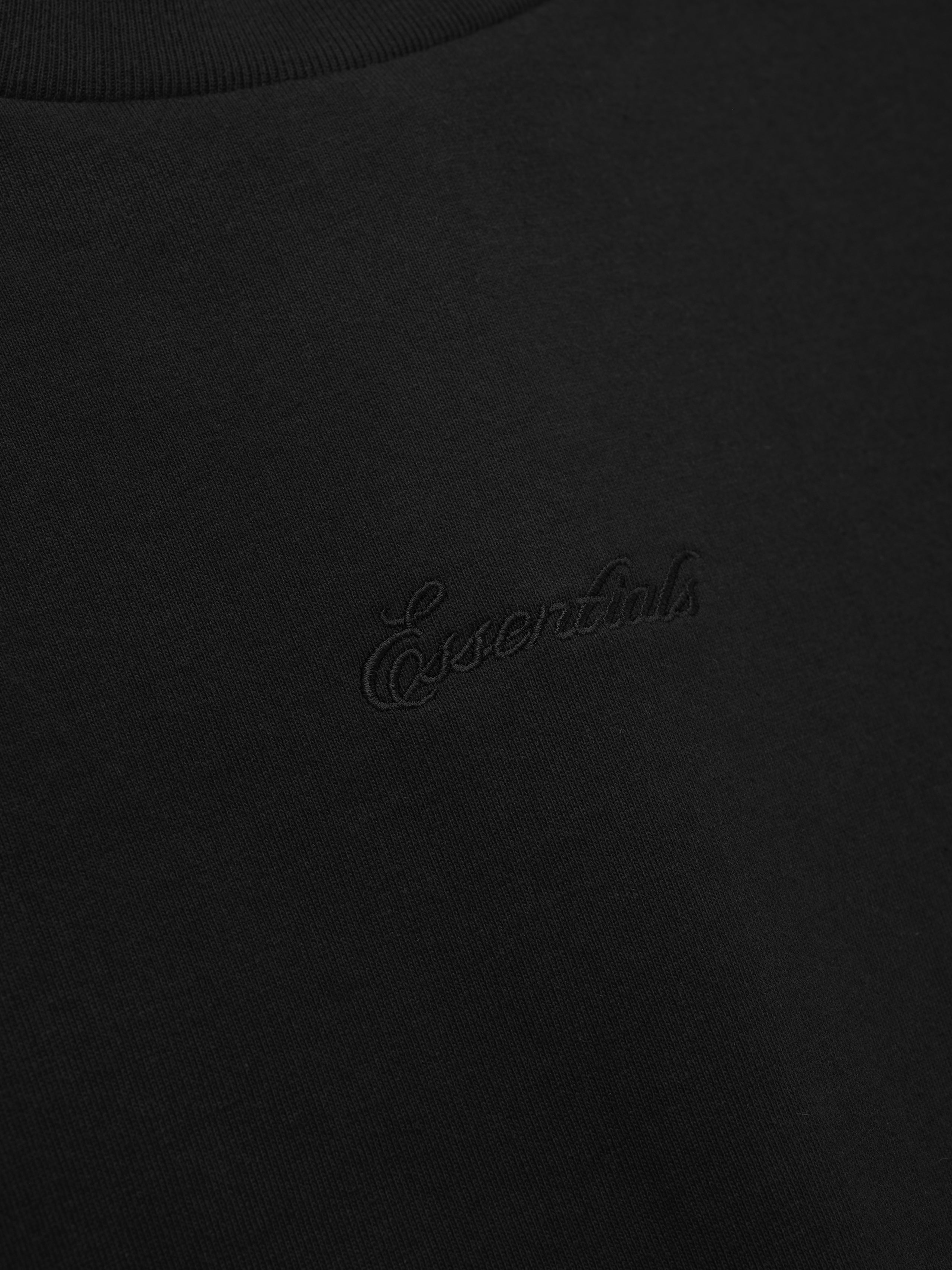 Close-up of a black tee with embroidery.