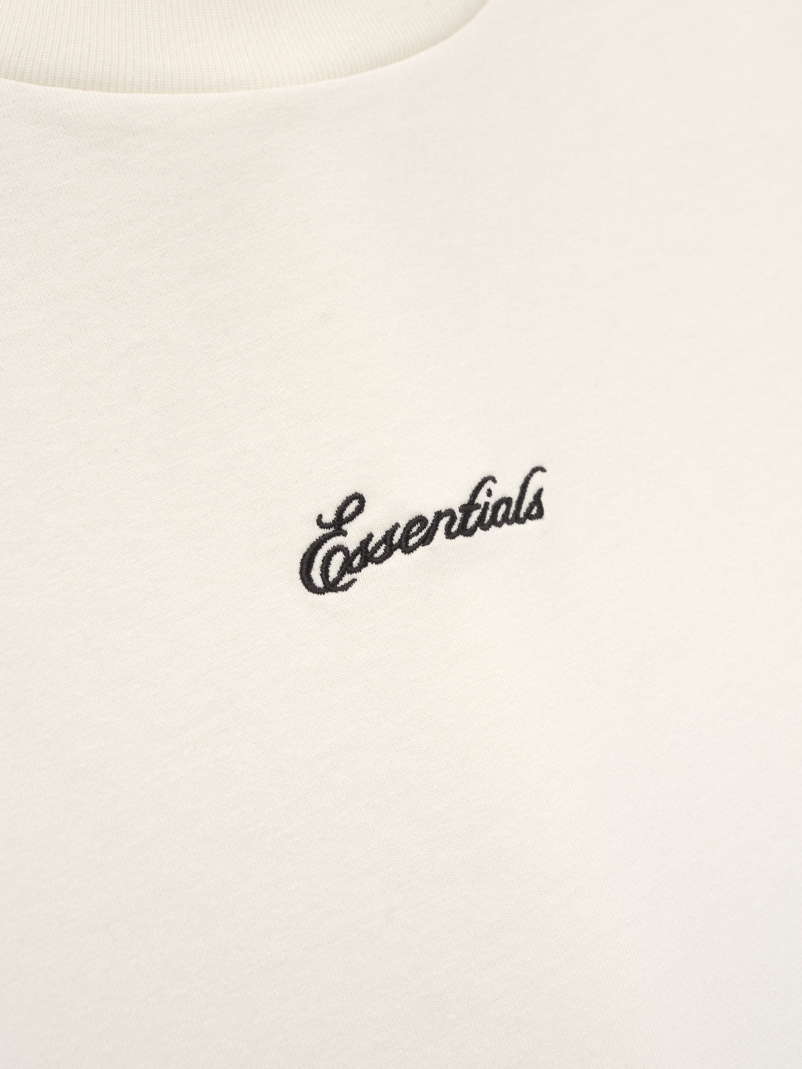 White t-shirt with 'essentials' embroidery. 