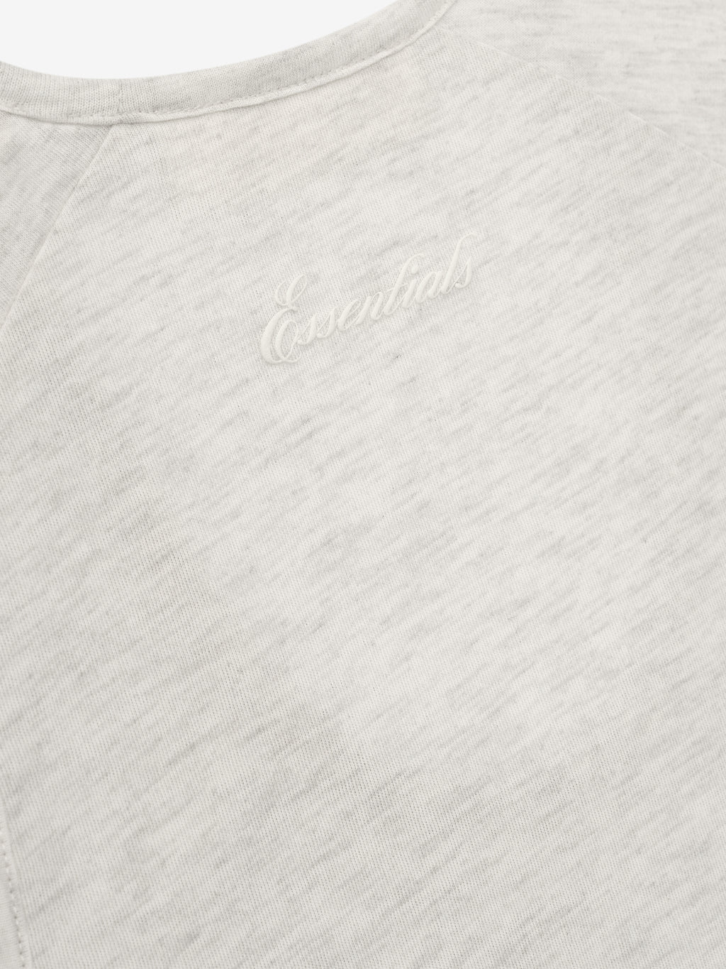 Close-up of a textured gray tank with Essentials script.