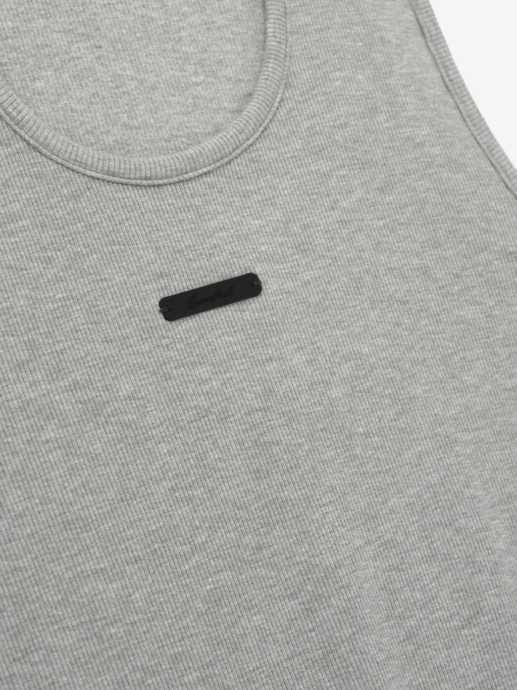 close-up of light gray ribbed cotton-rayon-spandex knit tank with U-neck and small black rectangular logo patch on chest