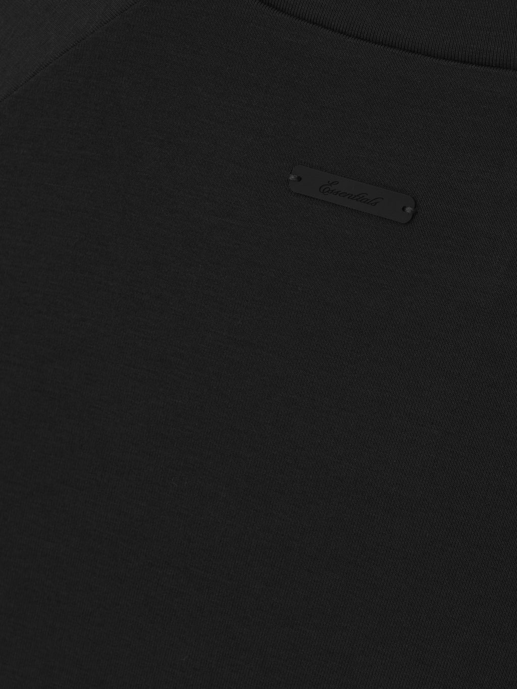 Close-up of a black shirt with a brand logo.