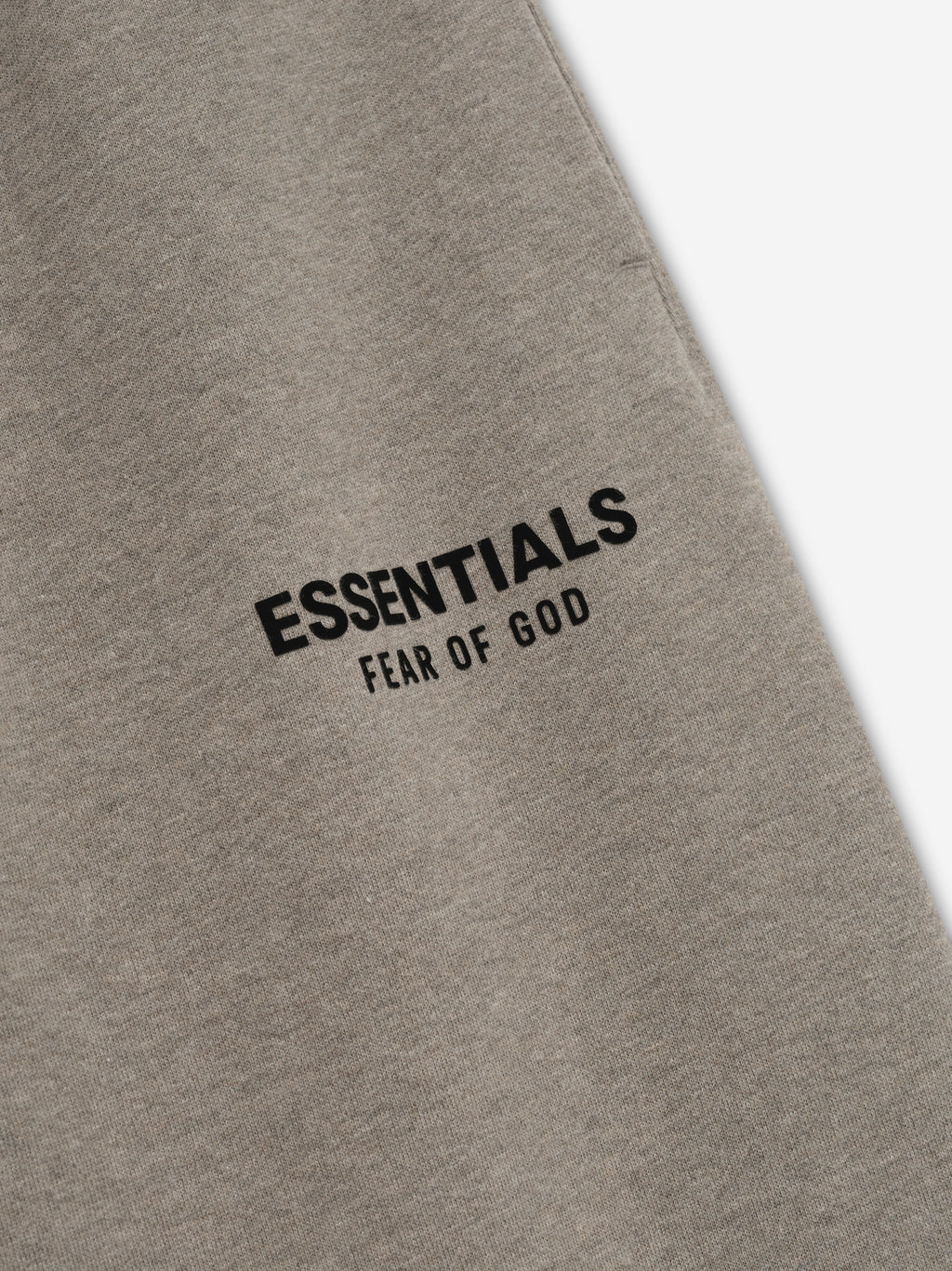 Gray sweatpants with 'Essentials Fear of God' text on a white background