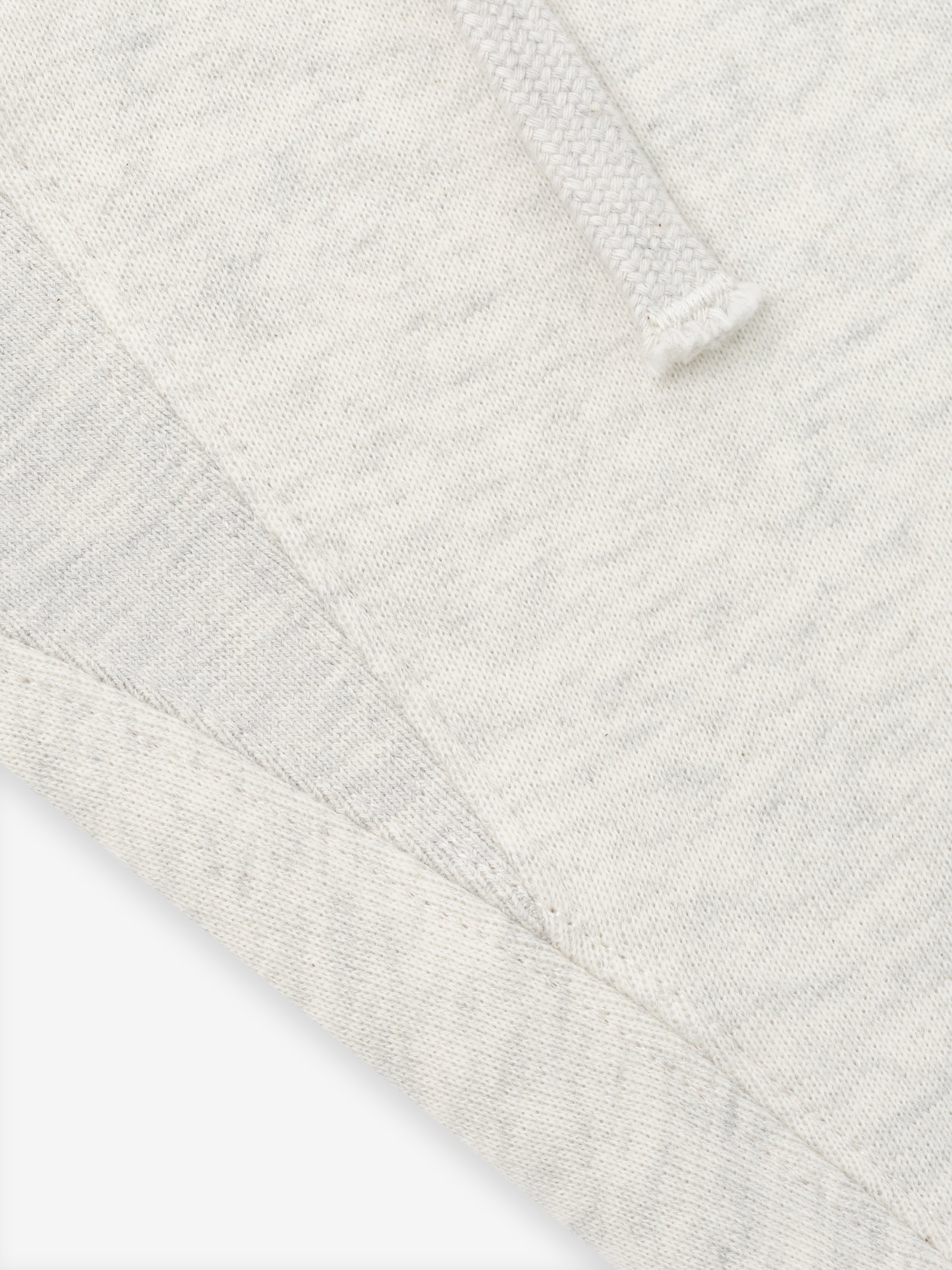 close-up of off-white fleece fabric with drawstring detail and visible seam on classic sweatpant waistband