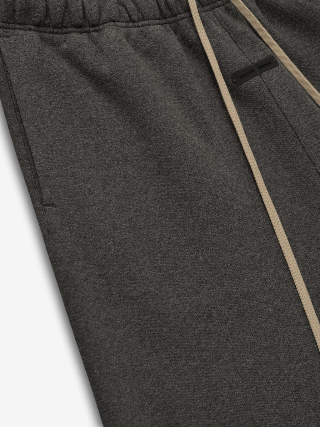 Close-up of charcoal heather flare sweatpant showing elastic waistband, beige drawstrings, side pocket, and fabric texture detail