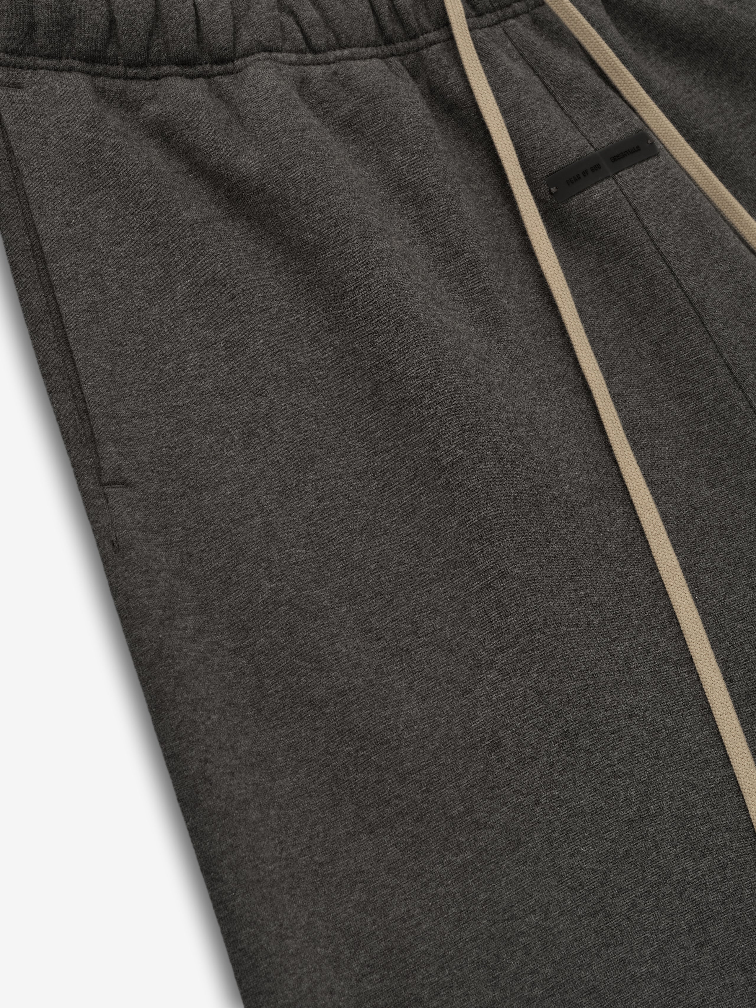 Close-up of charcoal heather flare sweatpant showing elastic waistband, beige drawstrings, side pocket, and fabric texture detail