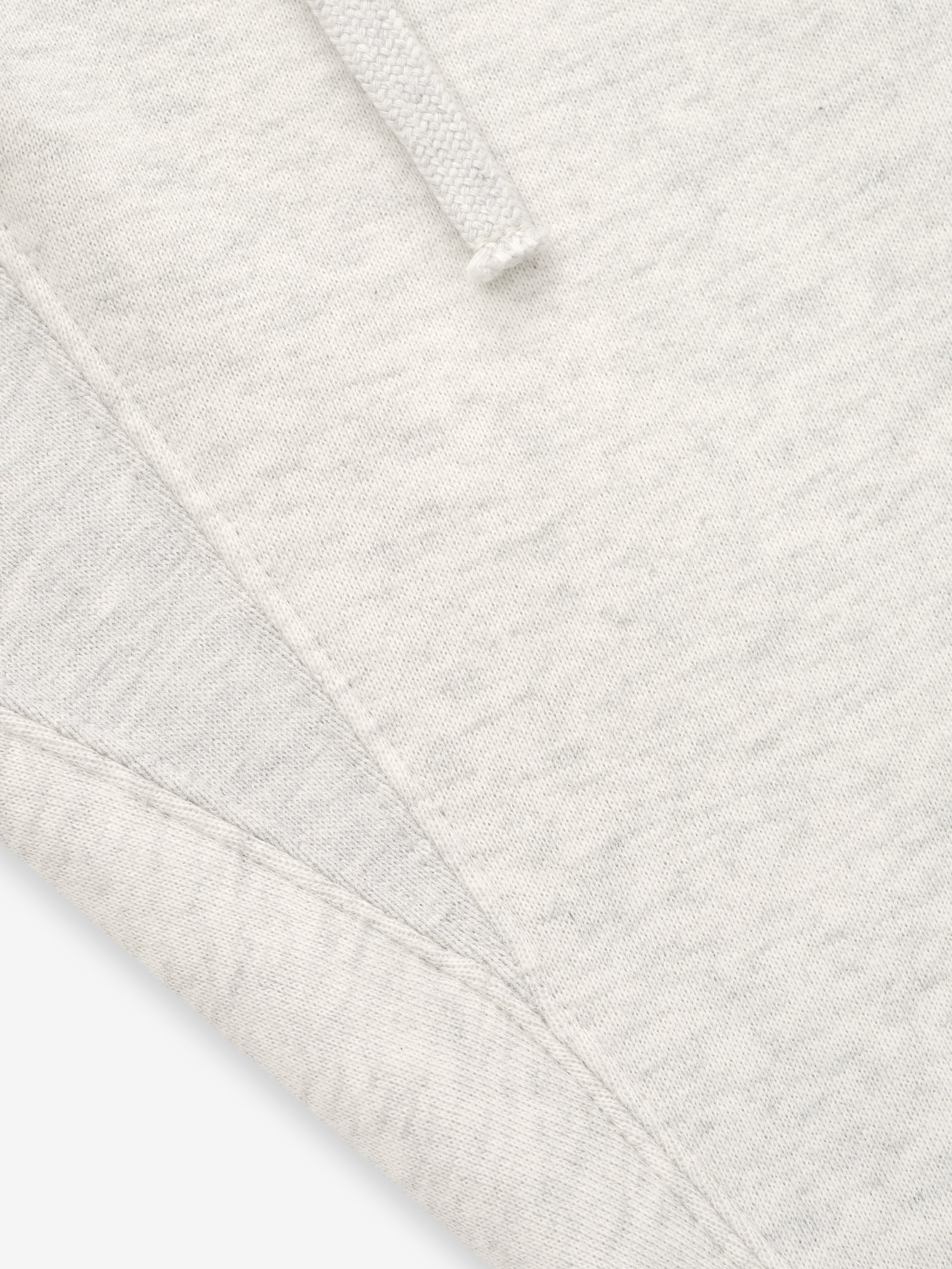 close-up of off-white core fleece fabric and stitching detail on relaxed fit sweatpants with drawstring waistband