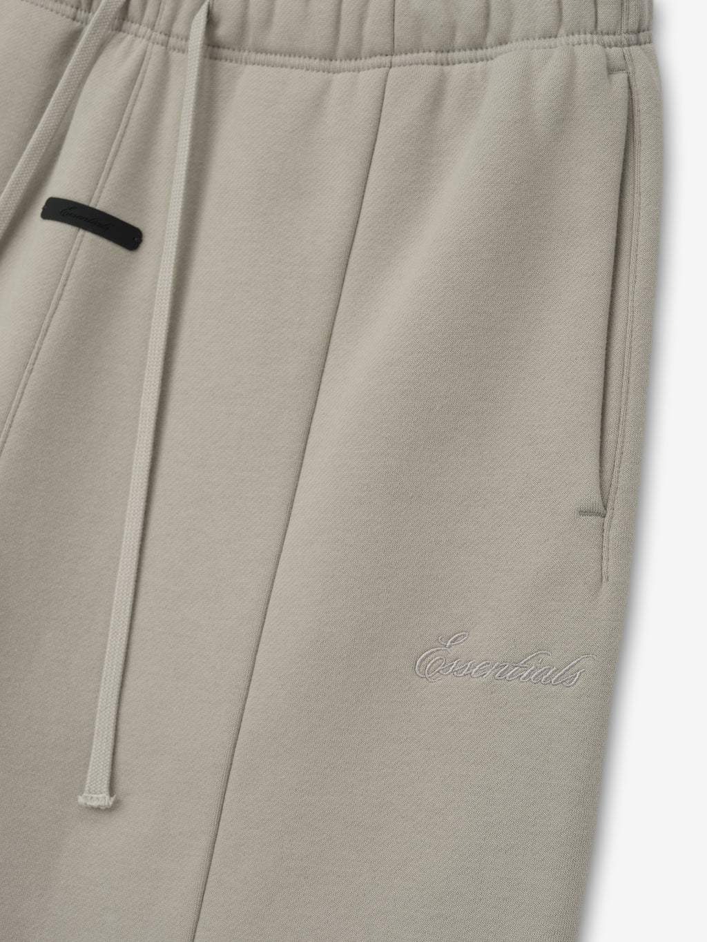 Grey sweatpants with an Essentials Signature logo on a white background