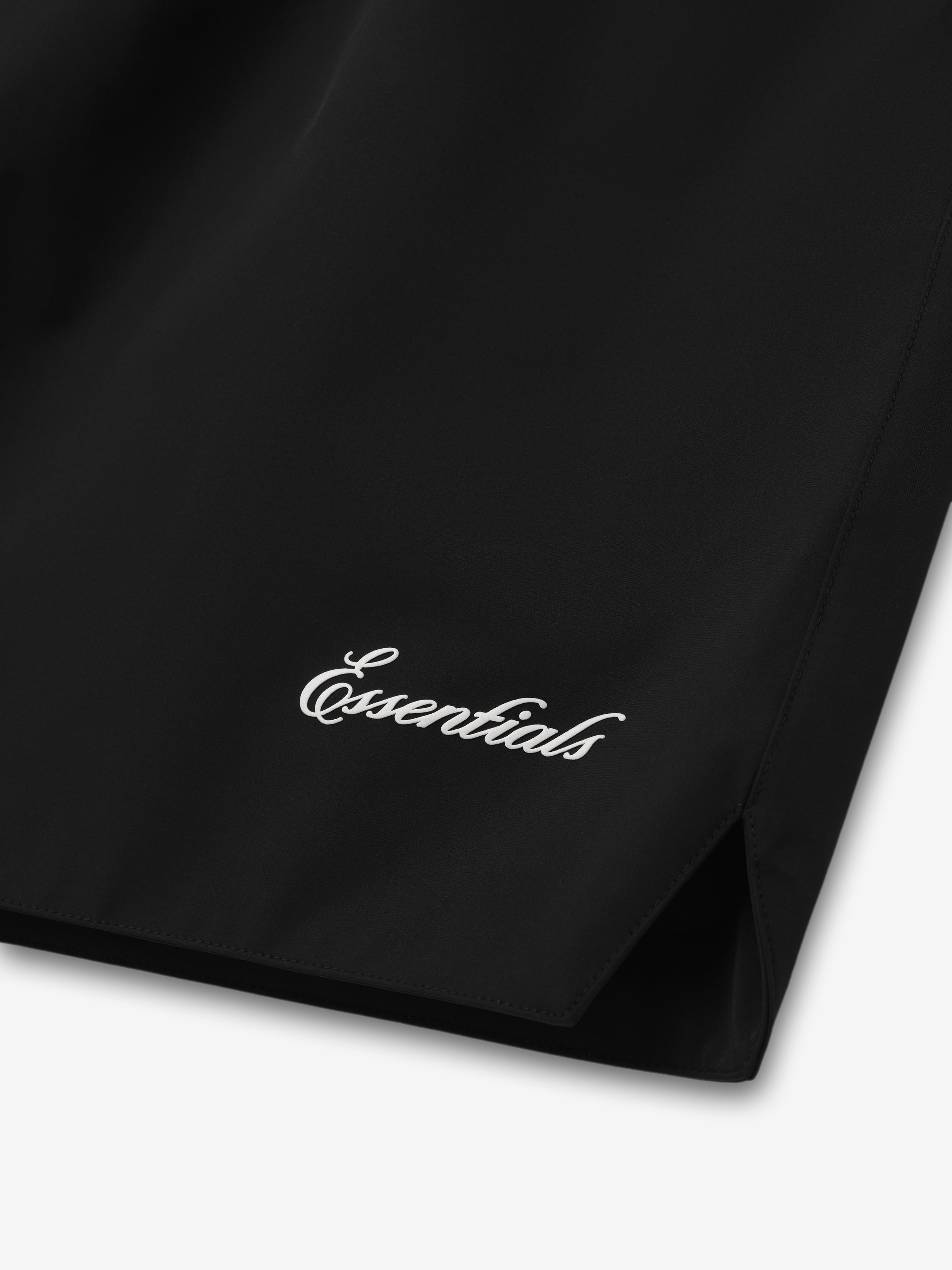 Close-up of black Spurs Classic Short showing white "Essentials" script near hem with side slit in gallery position zero