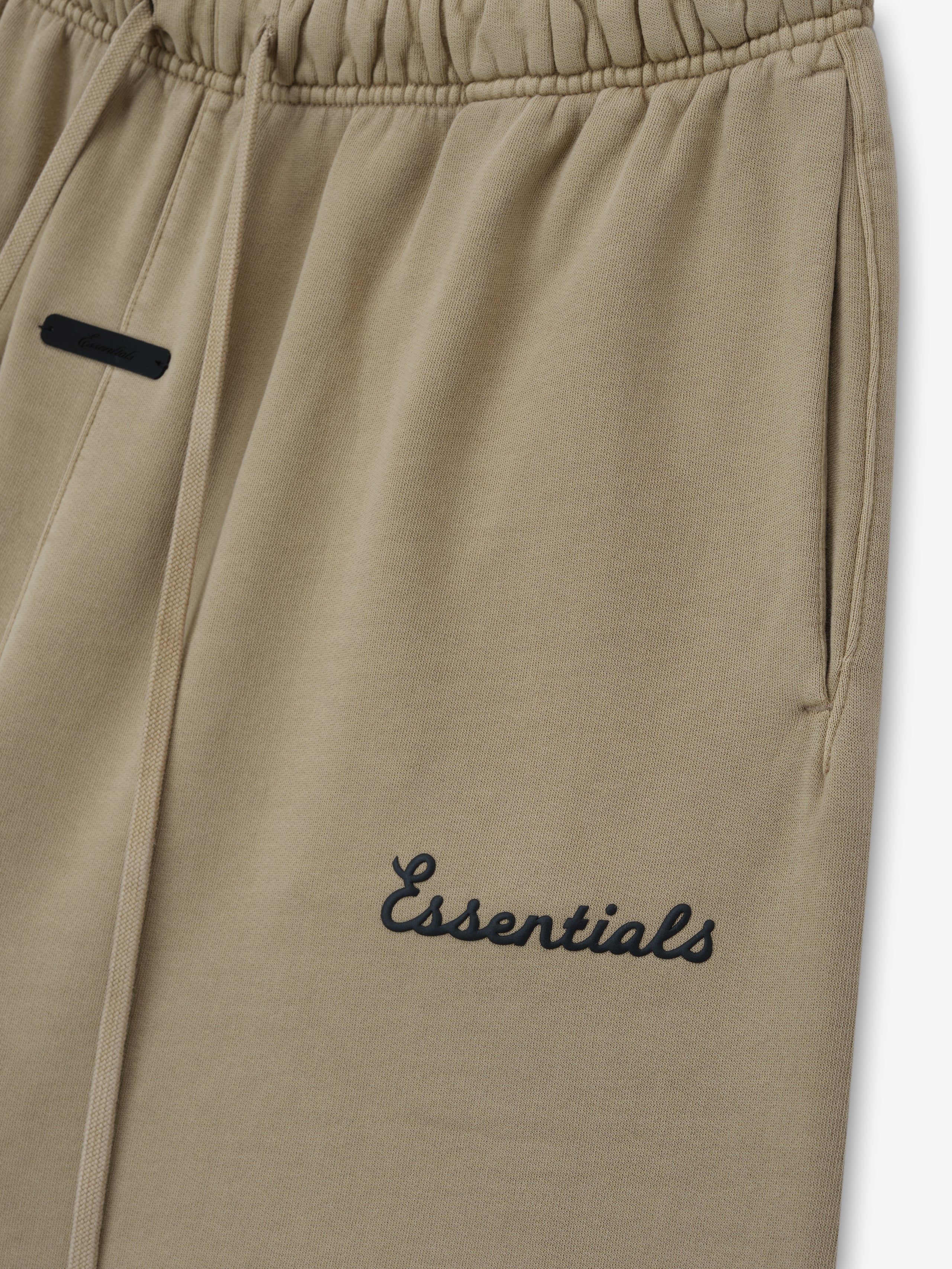 Beige short with 'Essentials' puff print on a white background