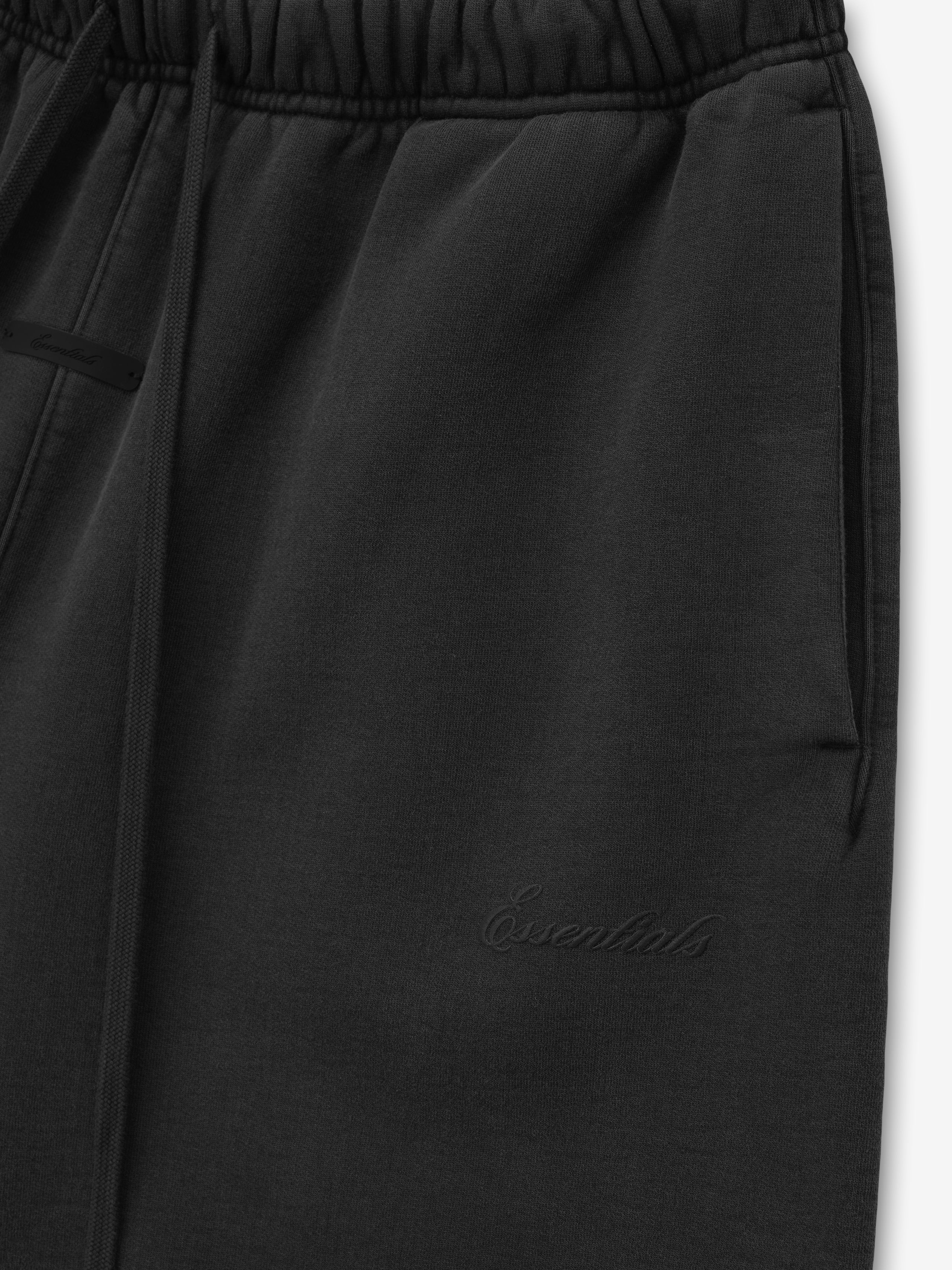 black heavyweight cotton fleece shorts with elastic waistband, side pockets, and discreet embroidered Essentials logo on leg