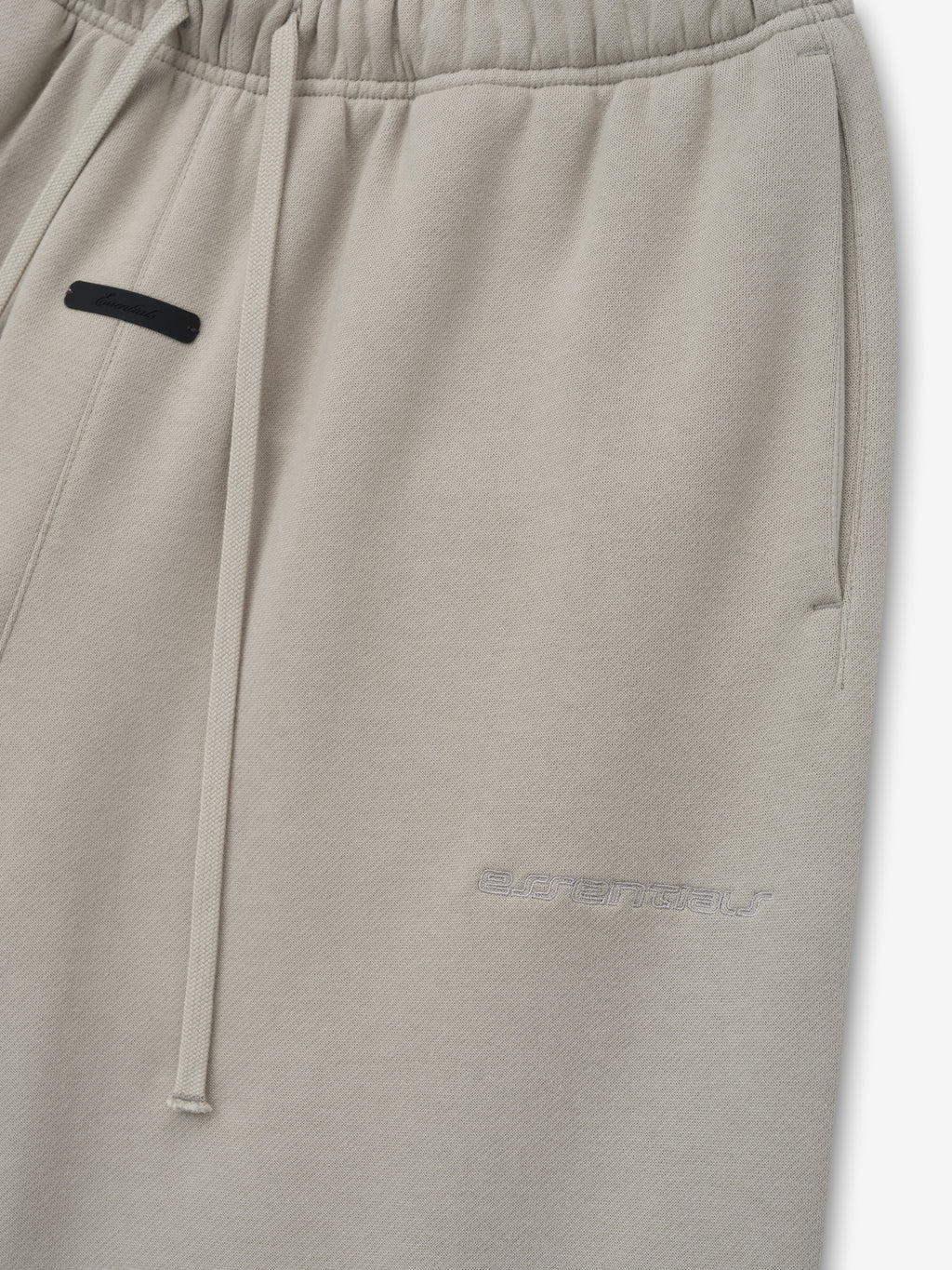 Grey sweatpants with a black patch on a white background