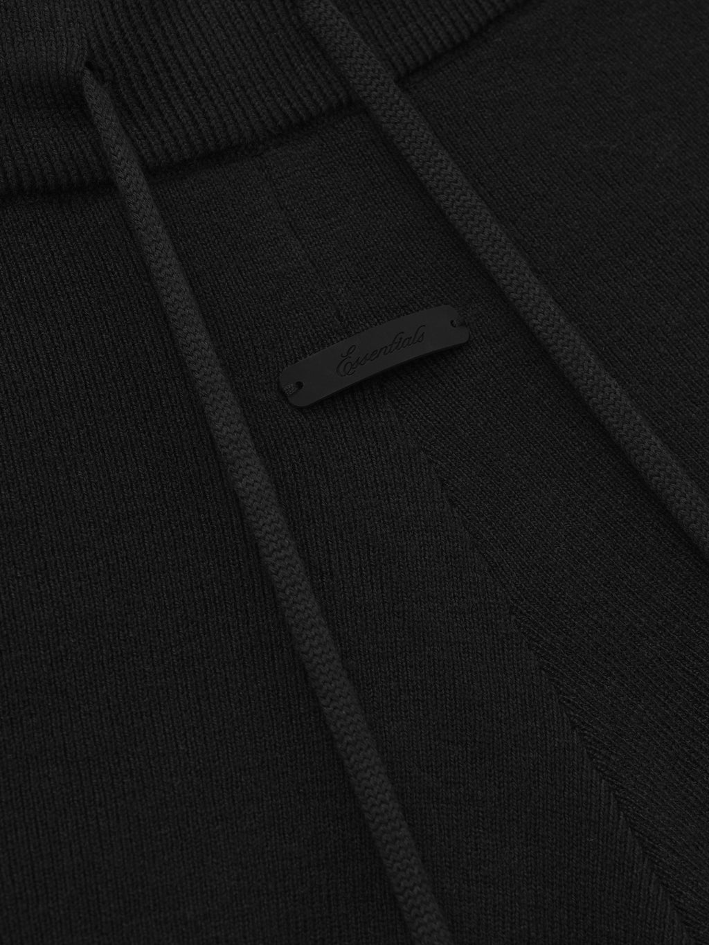 close-up of black rib knit fabric with drawstring and subtle branded tag detail on running shorts waistband