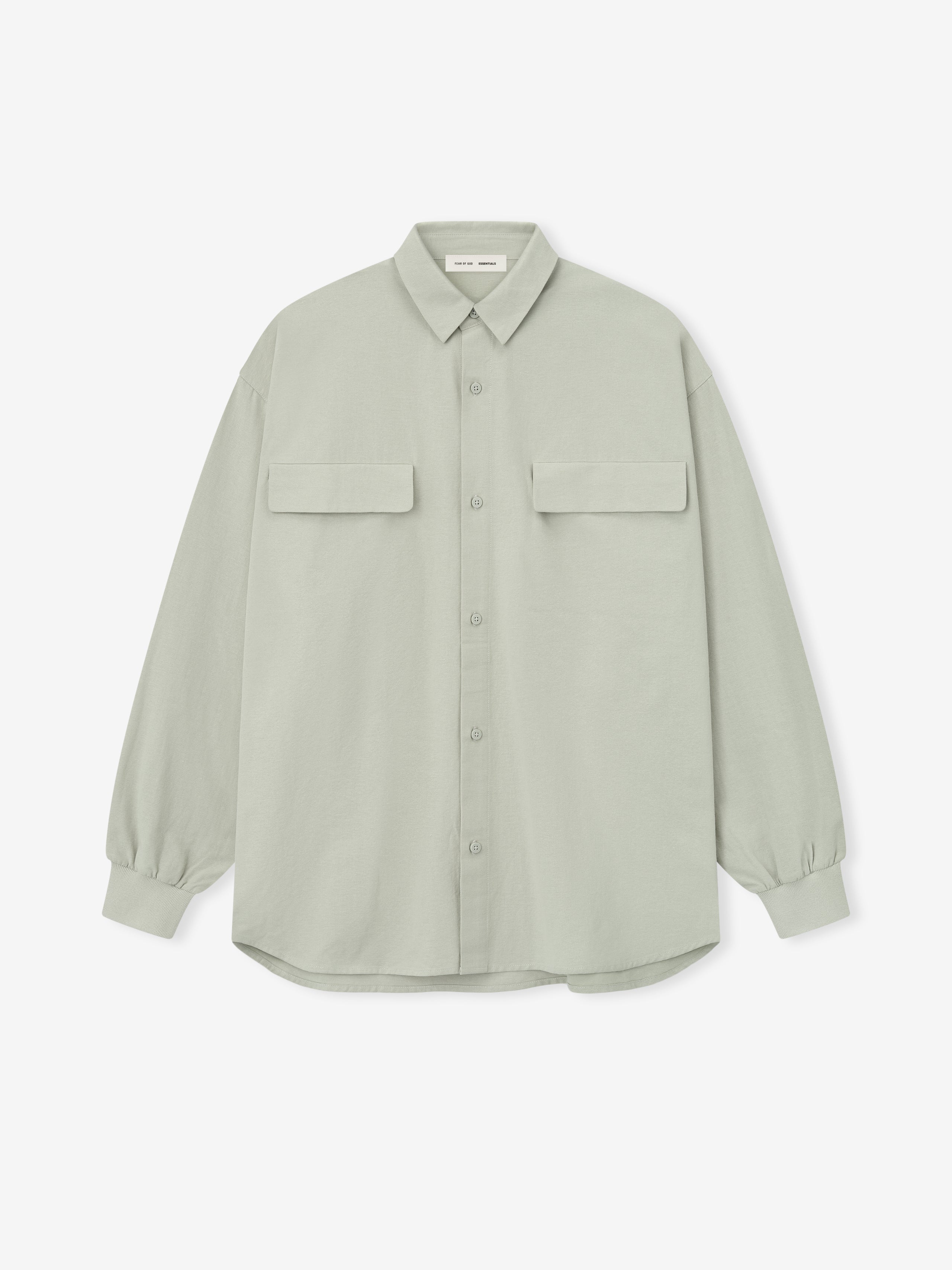 oversized light sage green Oxford shirt with flap chest pockets and buttoned cuffs laid flat on white background