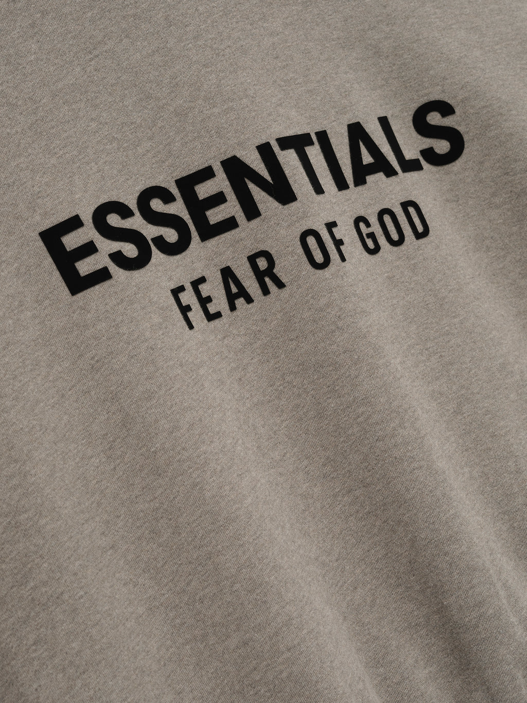 Close-up of Homestead Heather fleece fabric showing black Essentials Fear of God logo print on Classic Full Zip Up Hoodie