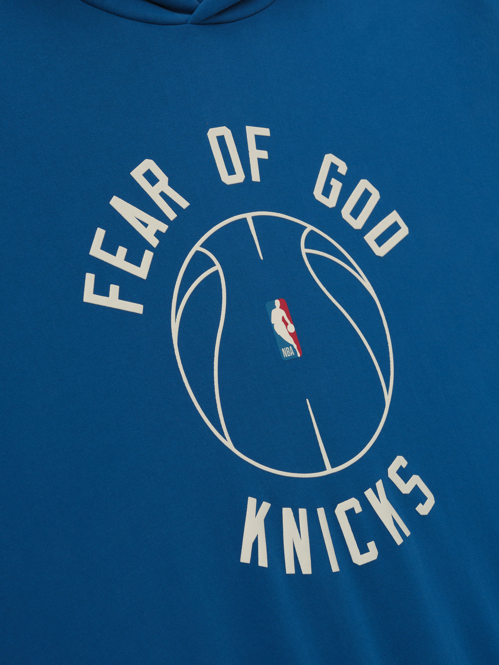 blue hoodie with puff-printed Fear of God Knicks text and NBA basketball graphic on front center