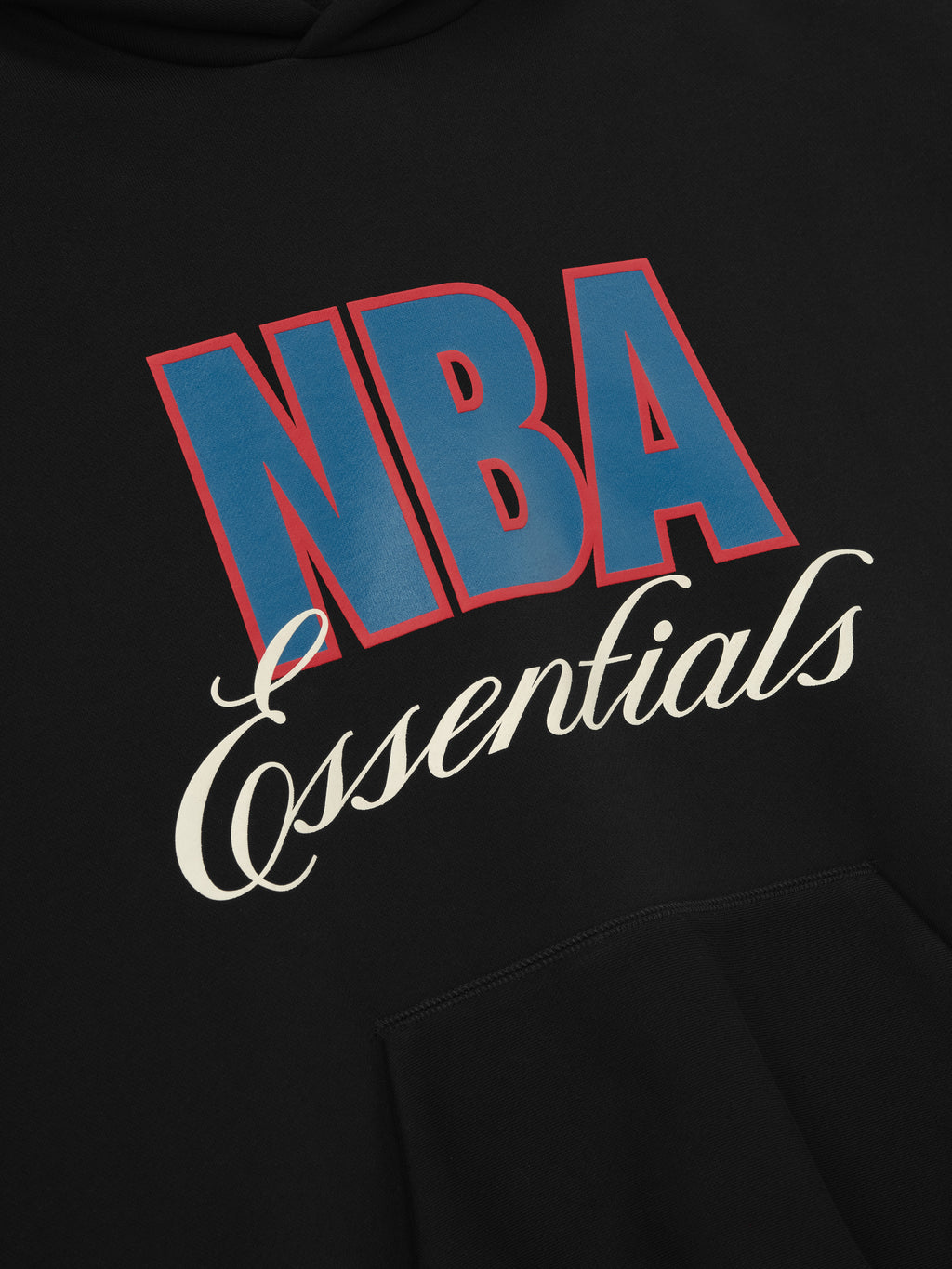 Black NBA 90s Hoodie close-up showing blue and red NBA text with white Essentials script above the kangaroo pocket