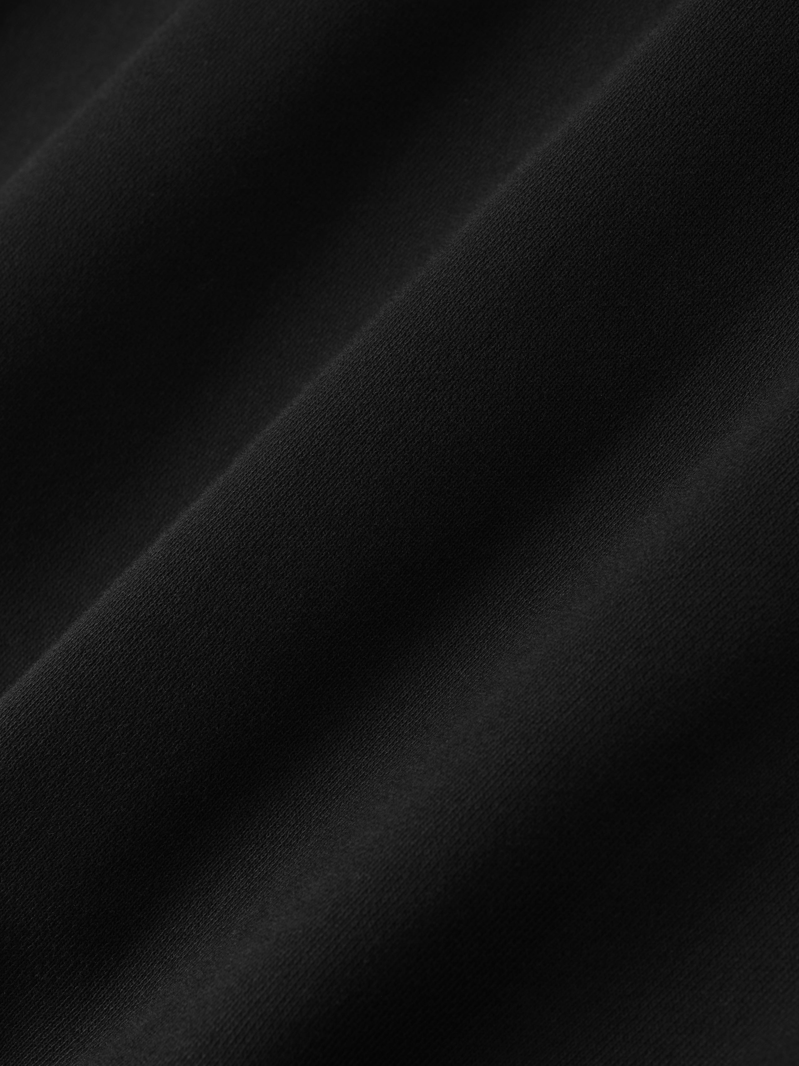 Close-up of smooth black fabric texture from NBA 90s Hoodie highlighting soft knit and matte finish detail